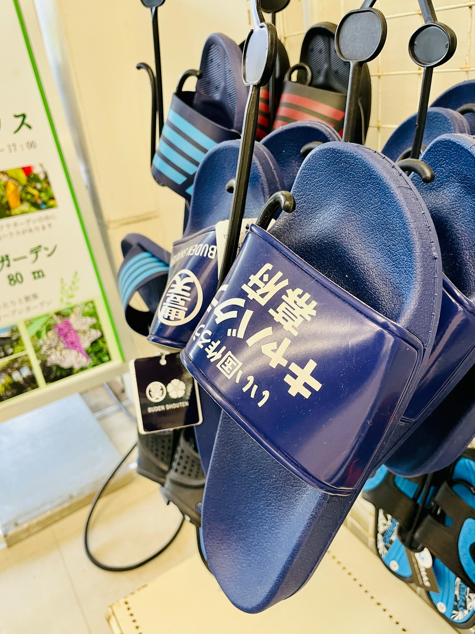 藍色拖鞋懸掛著，上面印有日文文字