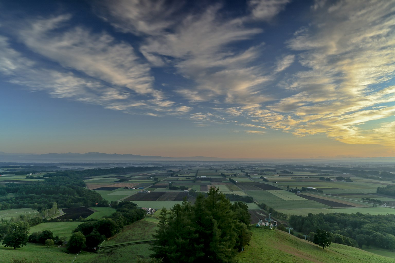 Expansive landscape with a colorful sky and cloud patterns
