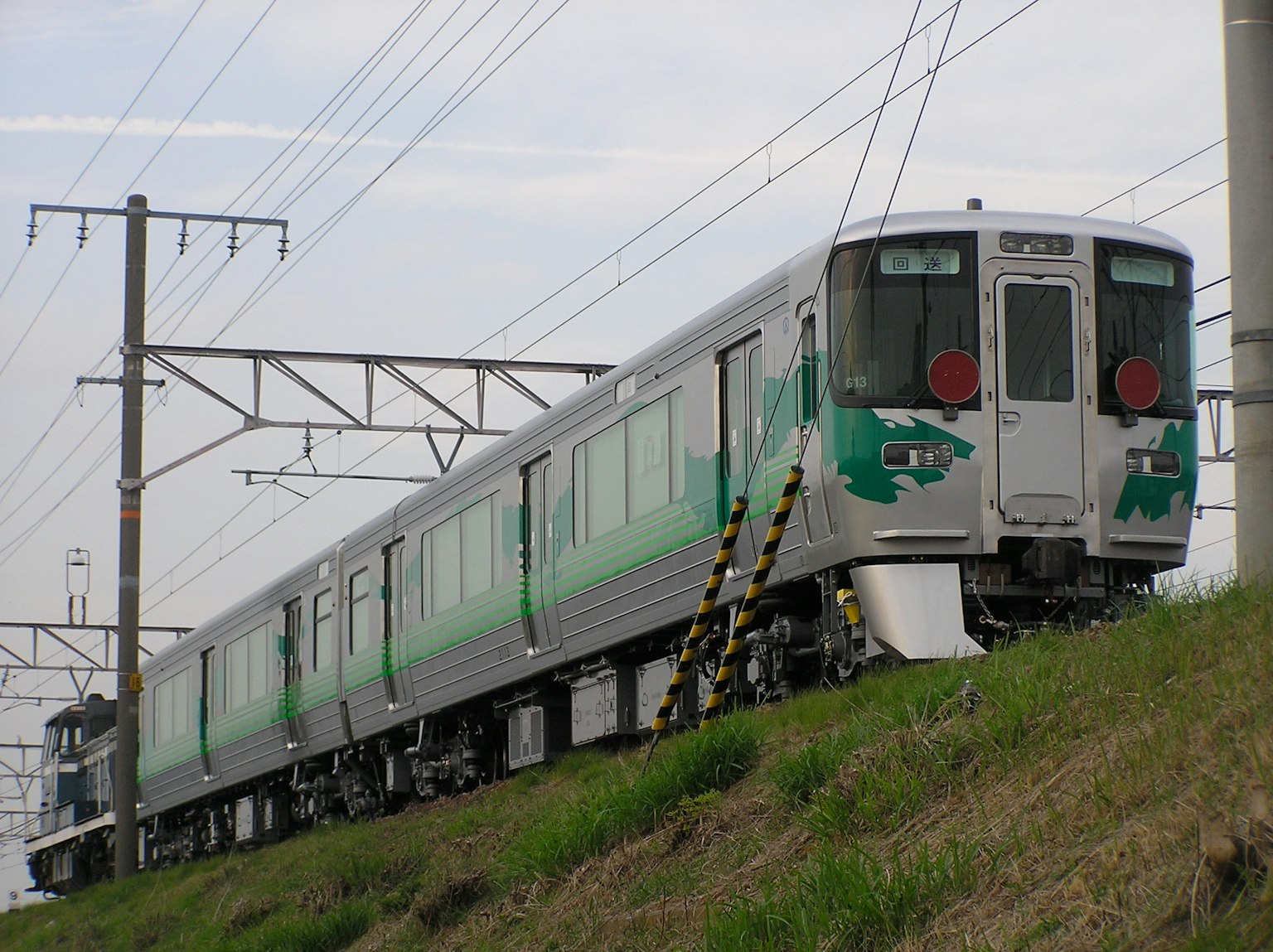 Un tren de temática verde estacionado al lado de las vías