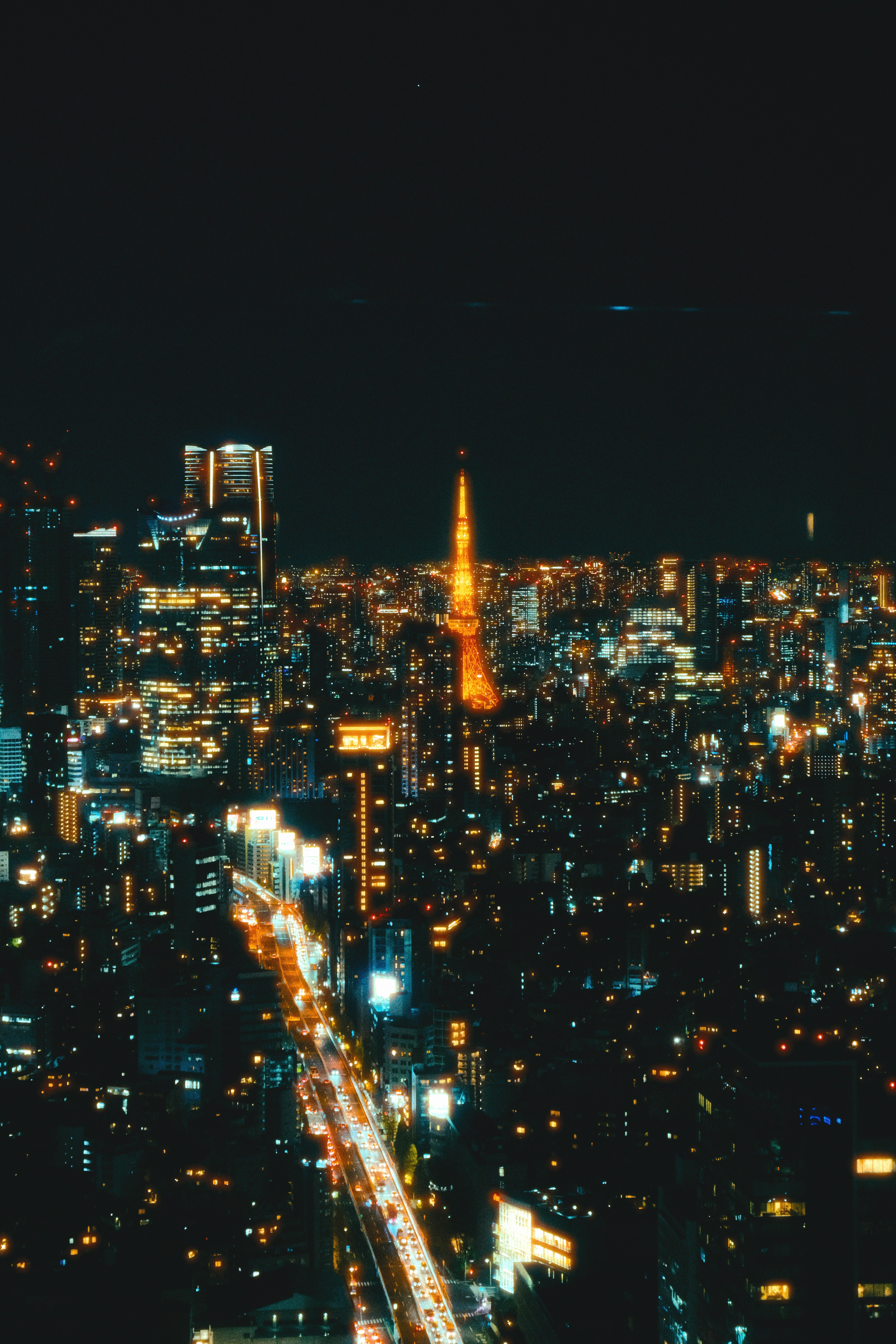 夜景の高層ビル群と光の大通り