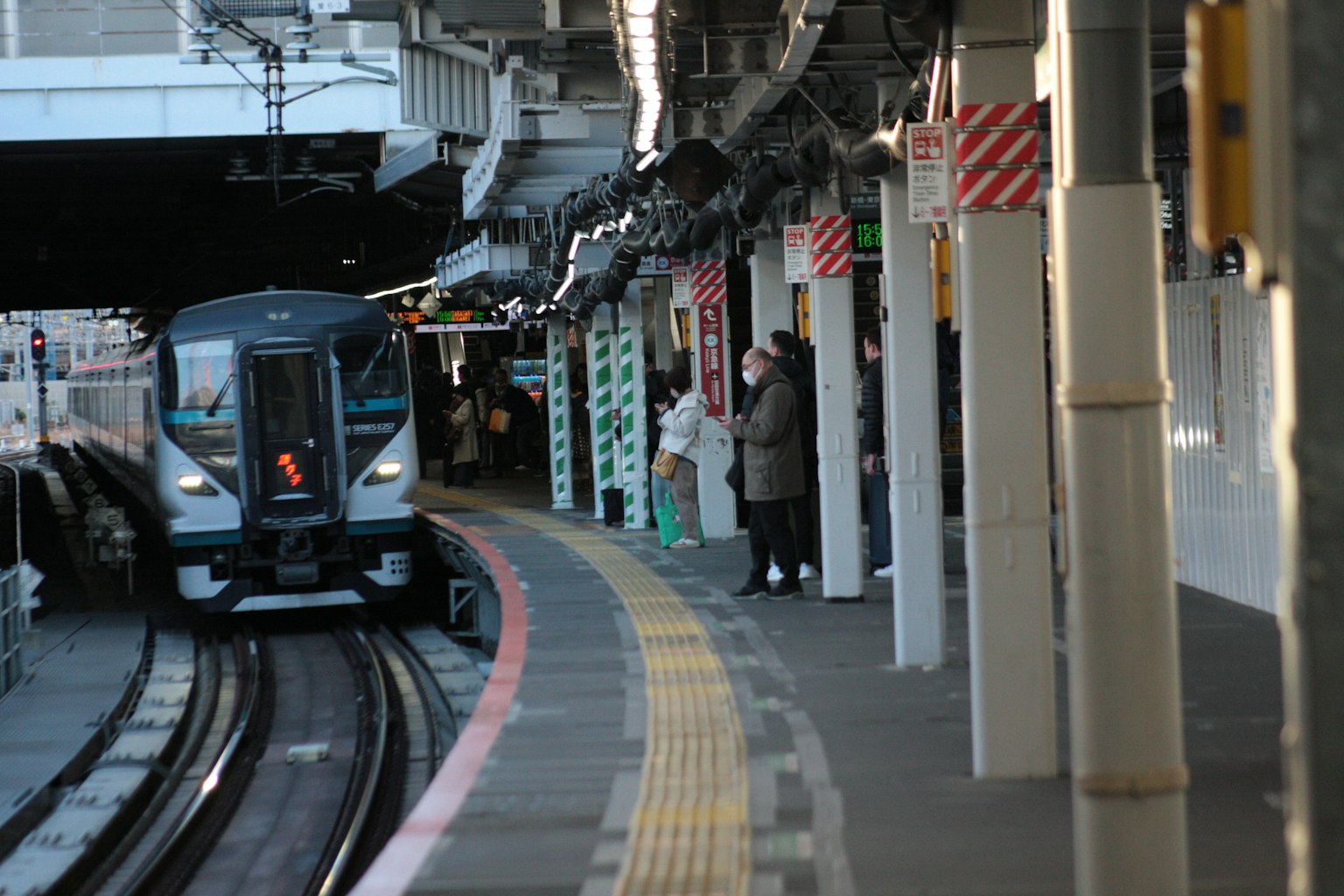 Penumpang menunggu di platform kereta dengan kereta yang tiba