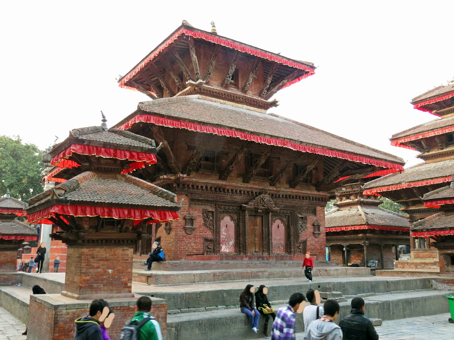 Vista de un complejo de templos nepalíes tradicionales con techos rojos y diseños intrincados