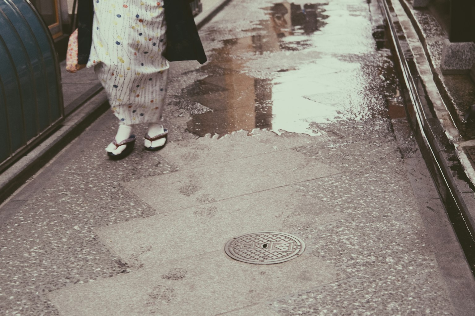 穿著和服的女性走在濕滑的街道上