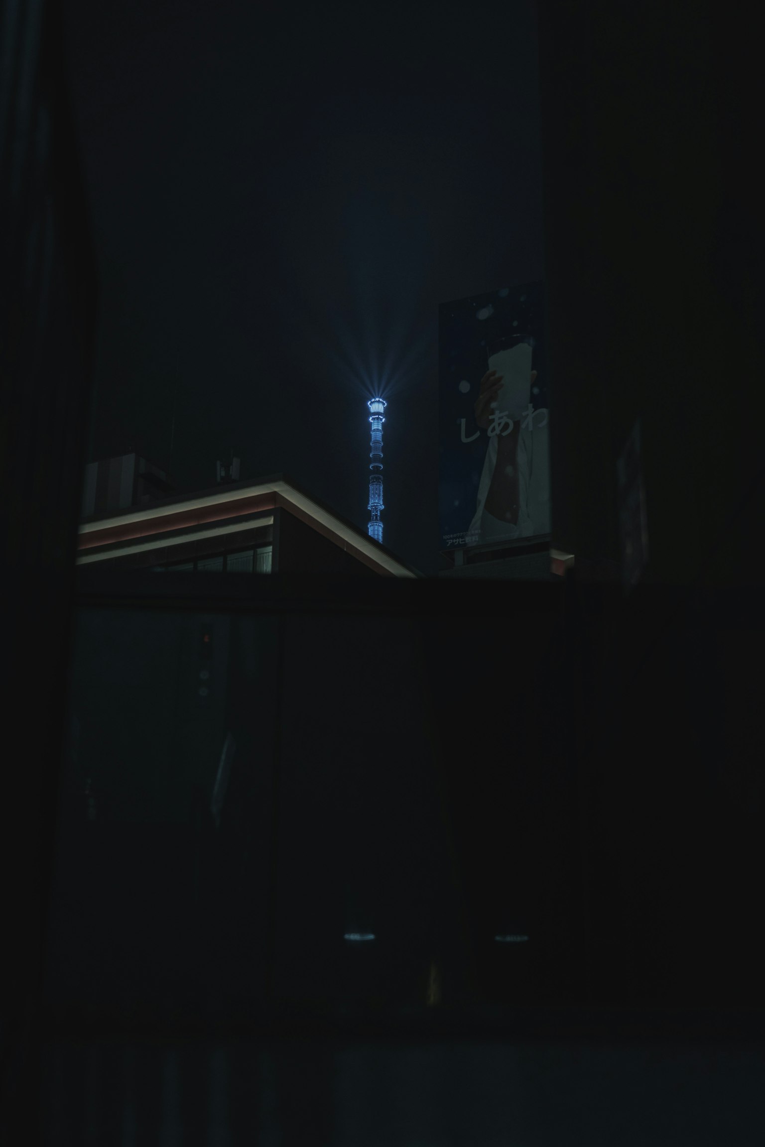 黑暗夜空中建筑与发光塔的轮廓