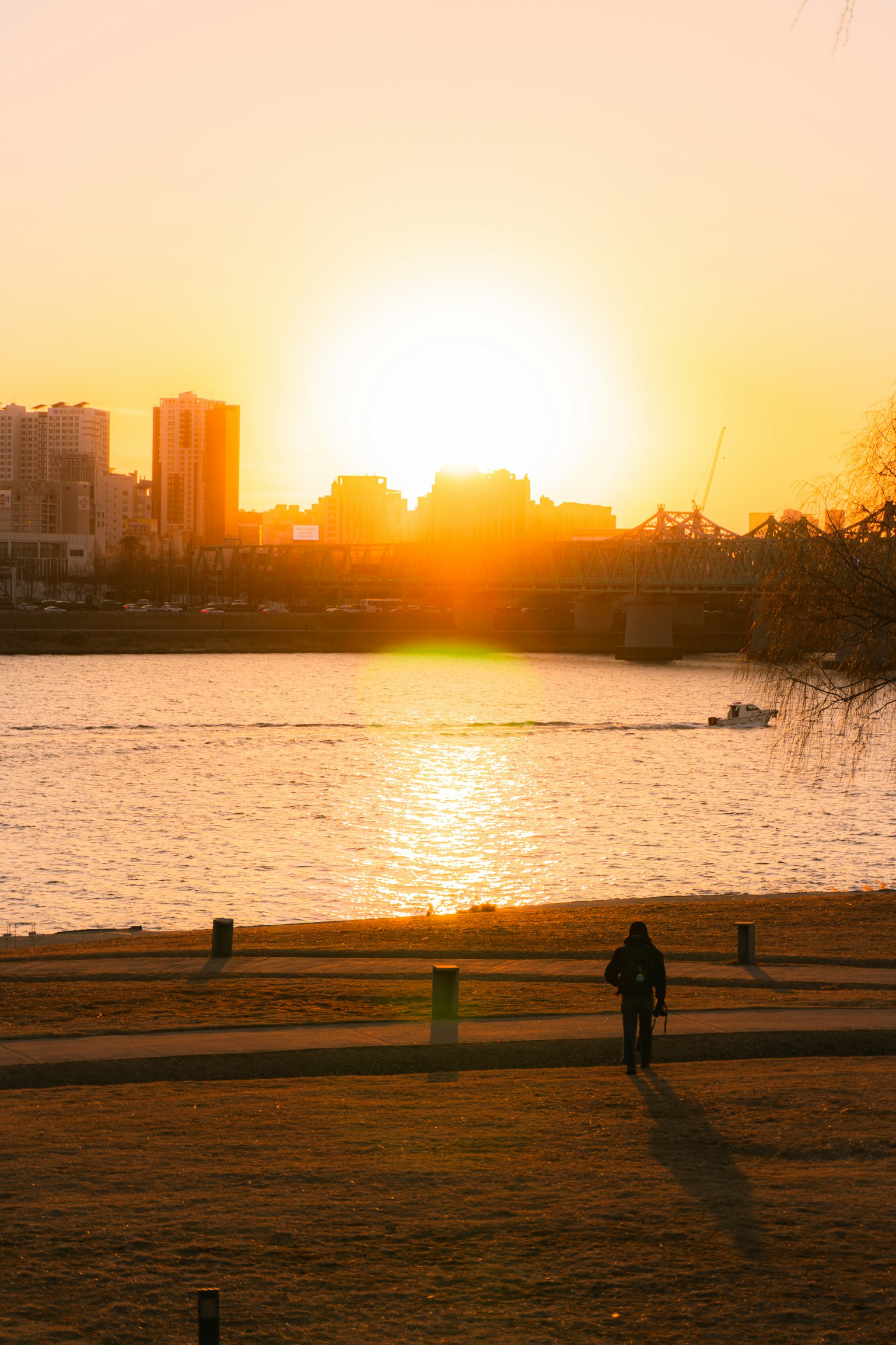 夕日が沈む川の景色とシルエットの人物
