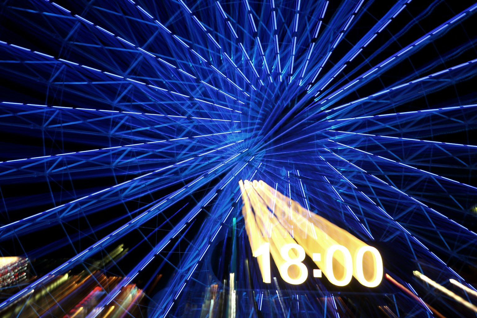 Nacht-Ferrisrad mit blauen Lichtern und Uhranzeige
