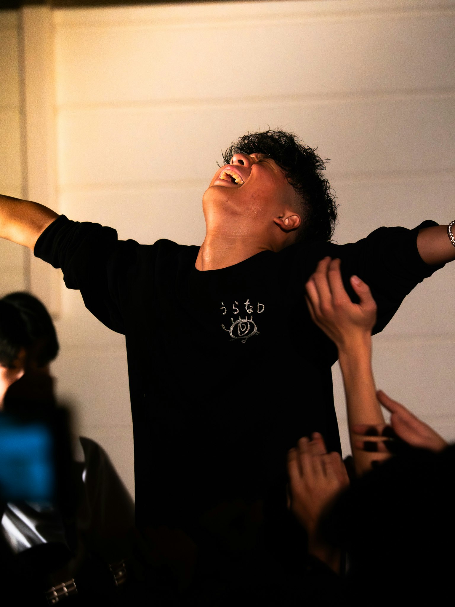 若者が喜びを表現しているシーン 周囲の人々が手を伸ばしている