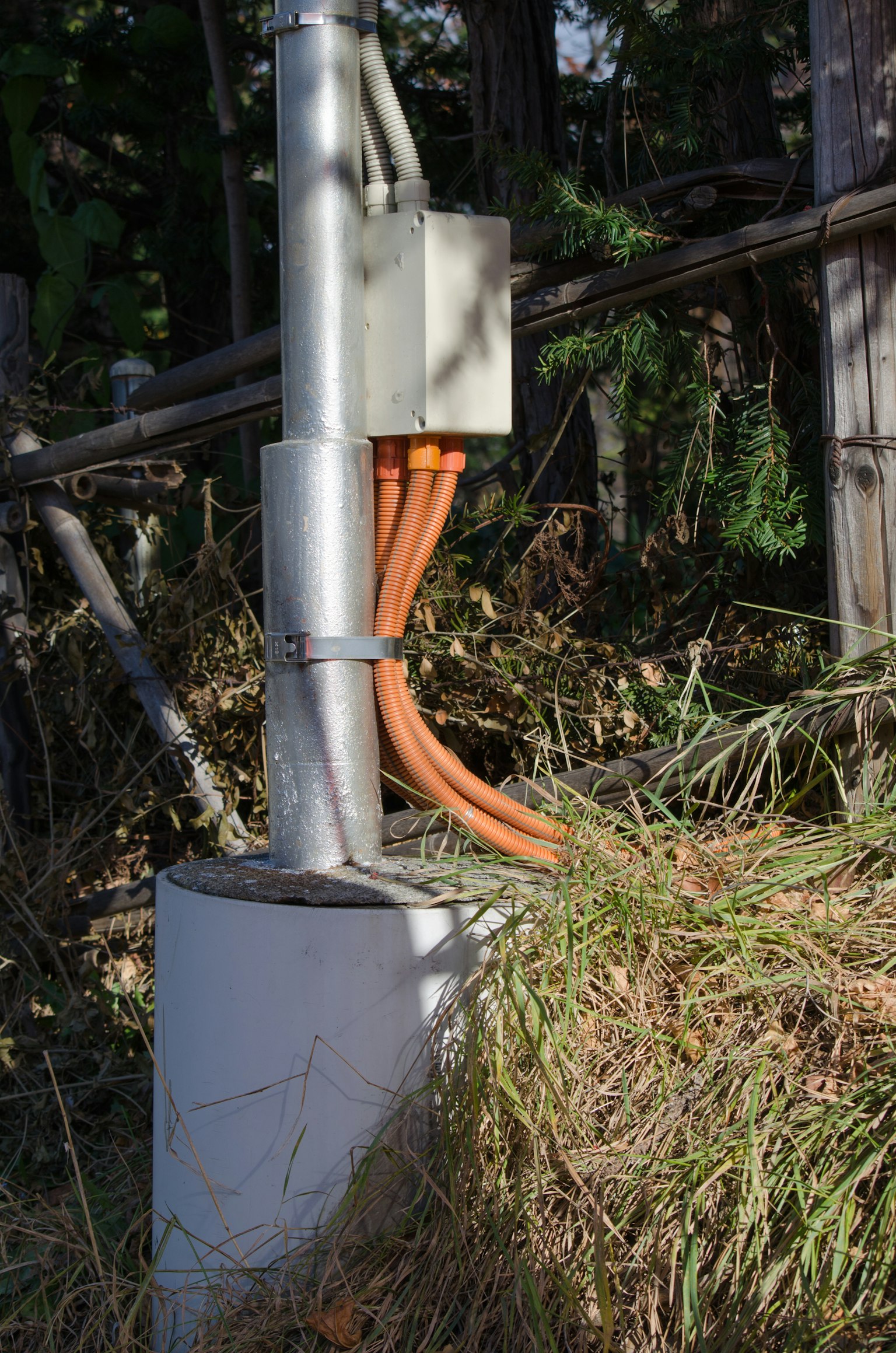 Photo of a metal pipe with orange wiring connected to a control box