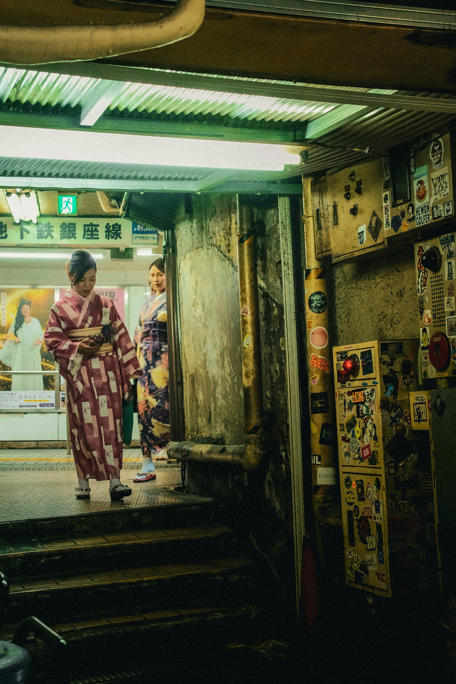 People in kimonos standing in a narrow alleyway by a storefront in Tokyo