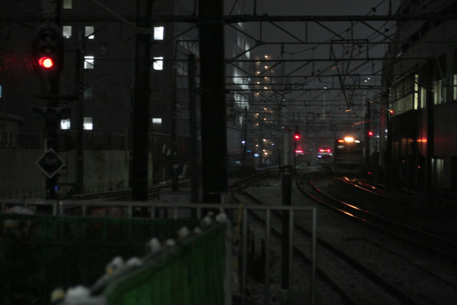 昏暗的城市铁路轨道和红色信号灯的夜景