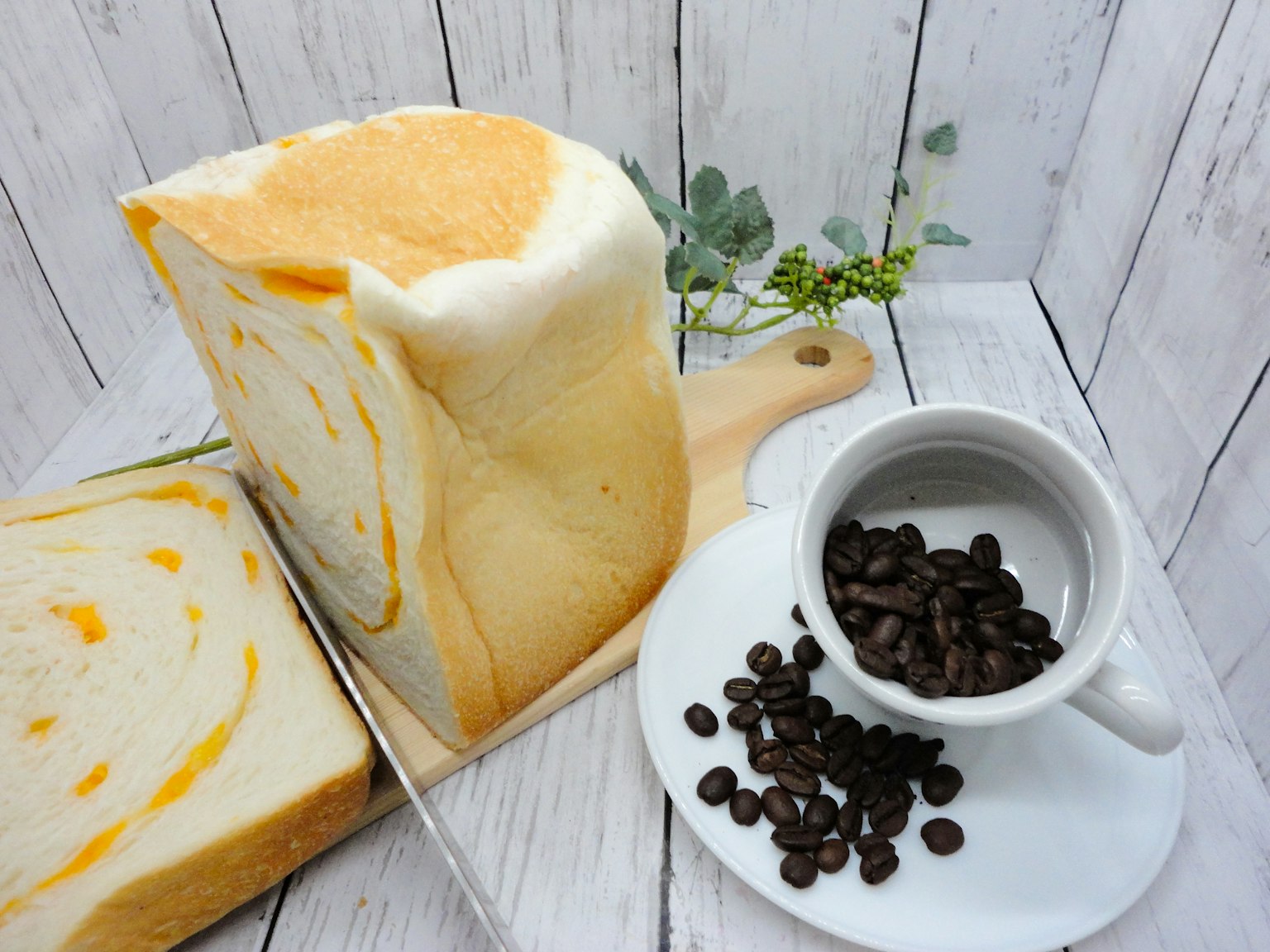 Roti marmer oranye dengan cangkir biji kopi di atas meja kayu