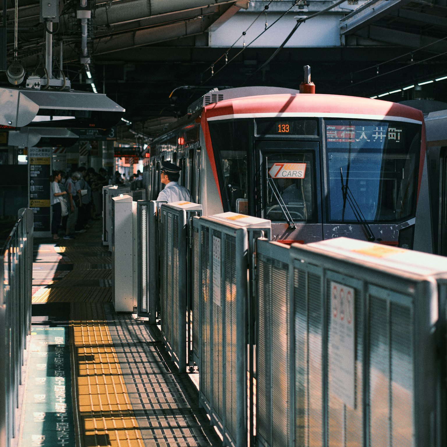 ฉากของสถานีรถไฟที่มีรถไฟสีแดงอยู่ที่ชานชาลา