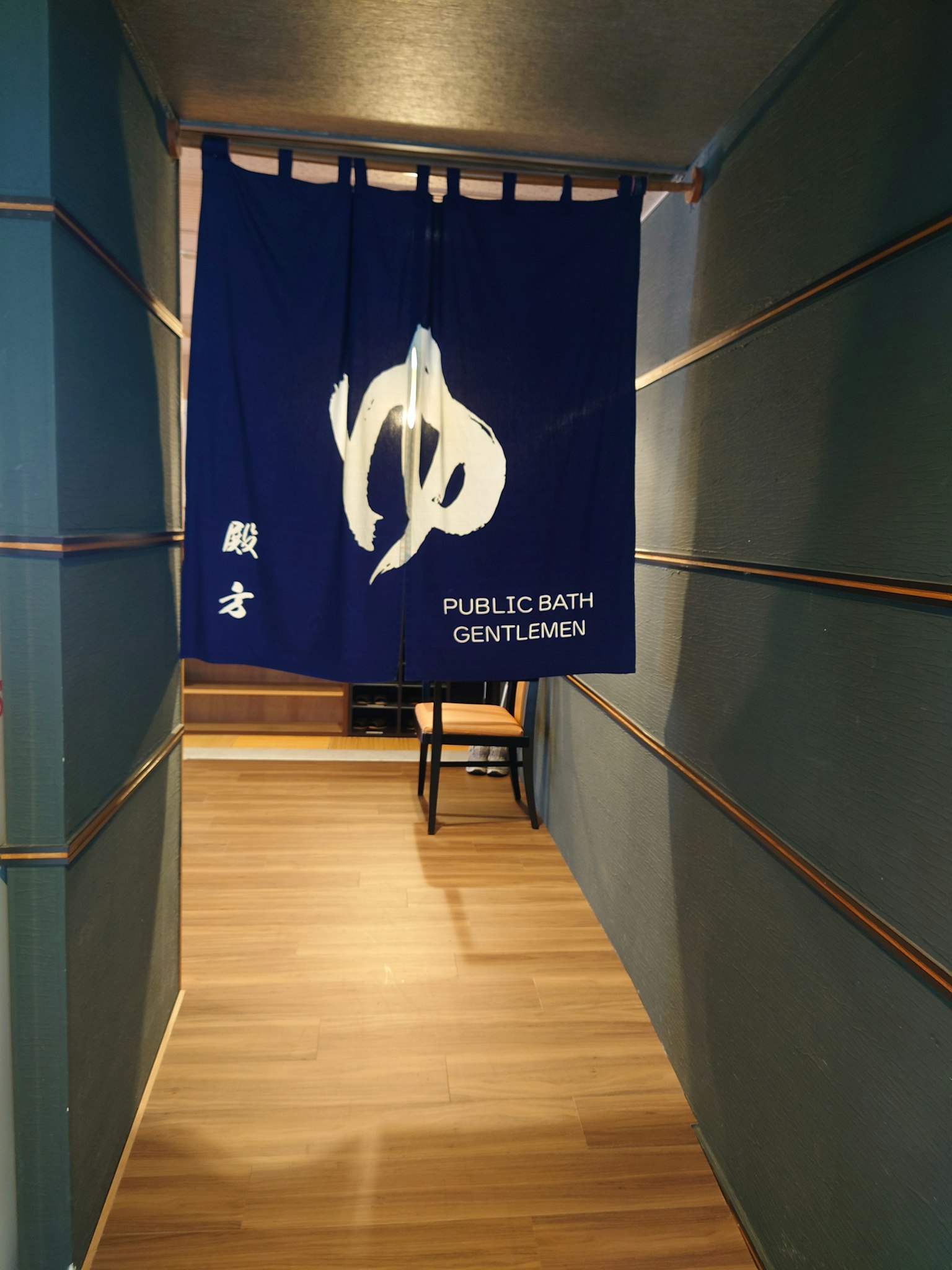 Pintu masuk lorong dengan tirai biru Noren tanda Mandi umum Pria