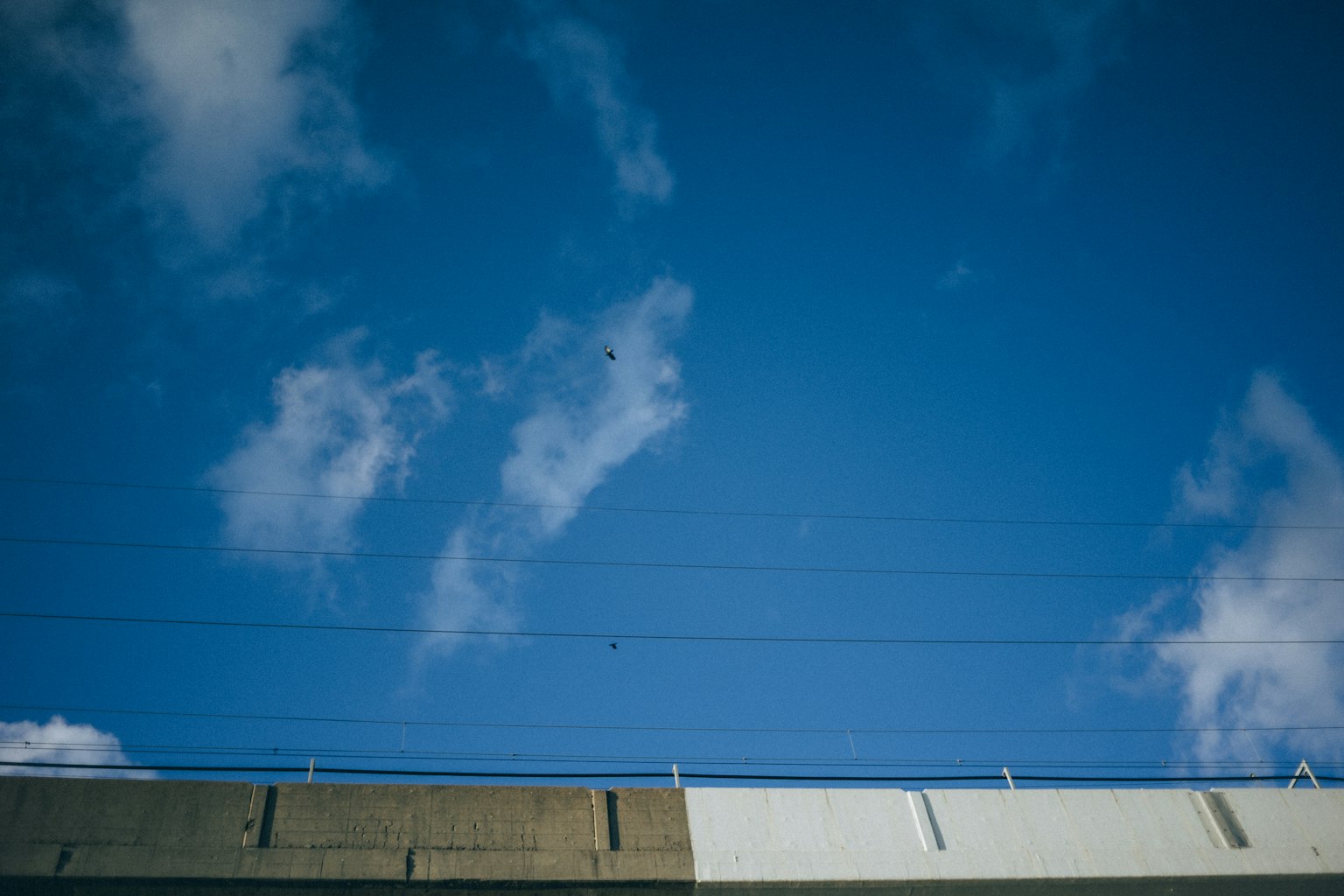Ciel bleu clair avec des nuages au-dessus d'une route en béton
