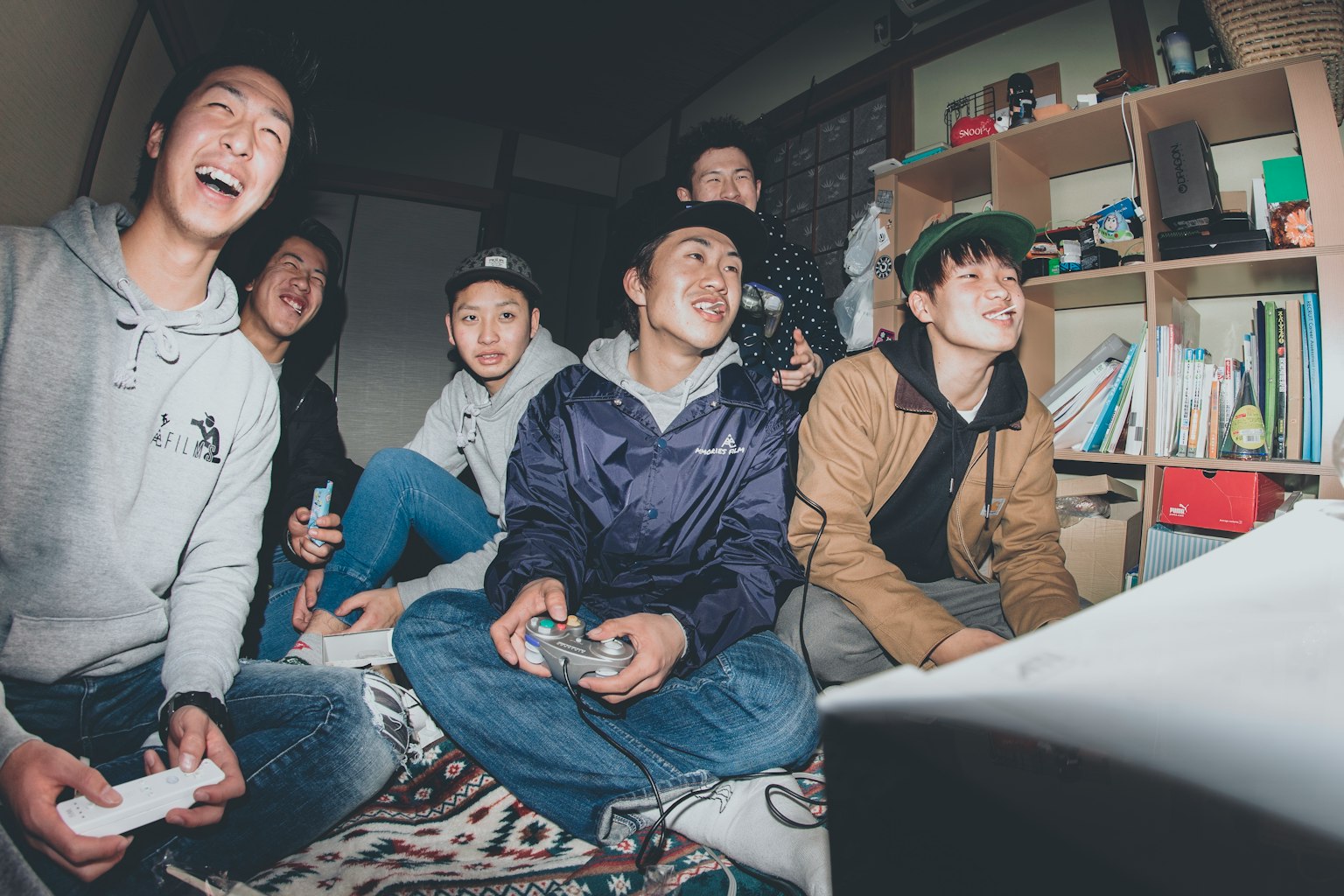 Gruppo di giovani che si divertono con i videogiochi ridendo e mostrando entusiasmo