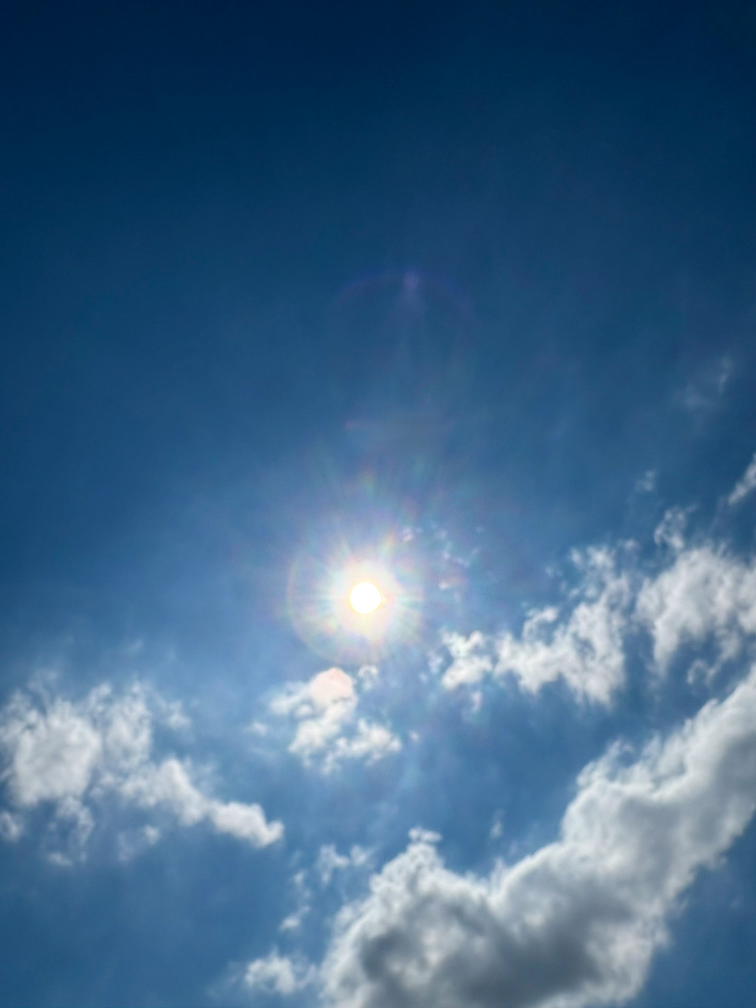 Sol brillante en un cielo azul claro con nubes blancas esponjosas