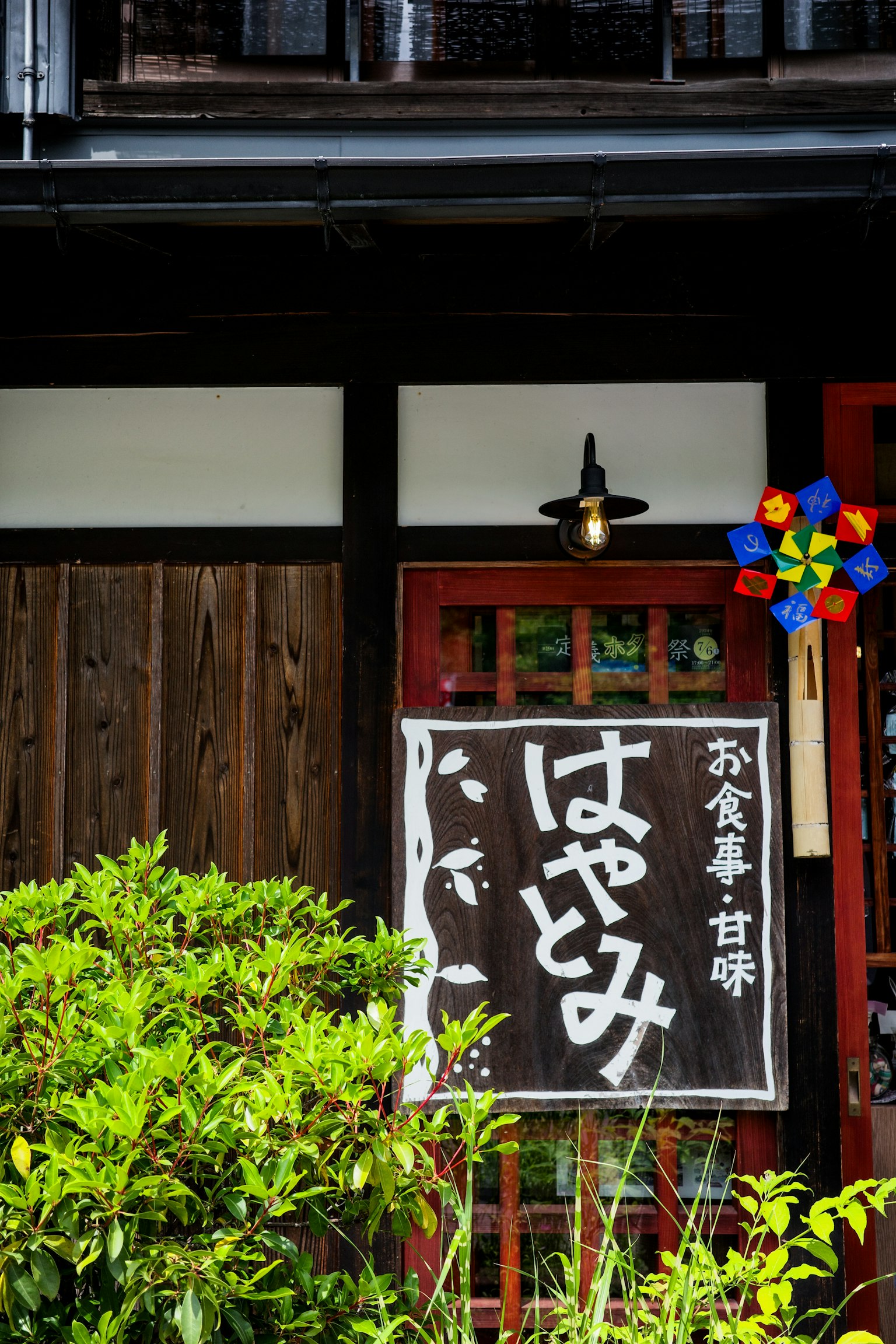 傳統日本餐廳外觀上有'はやみ'的招牌和茂盛的綠色植物