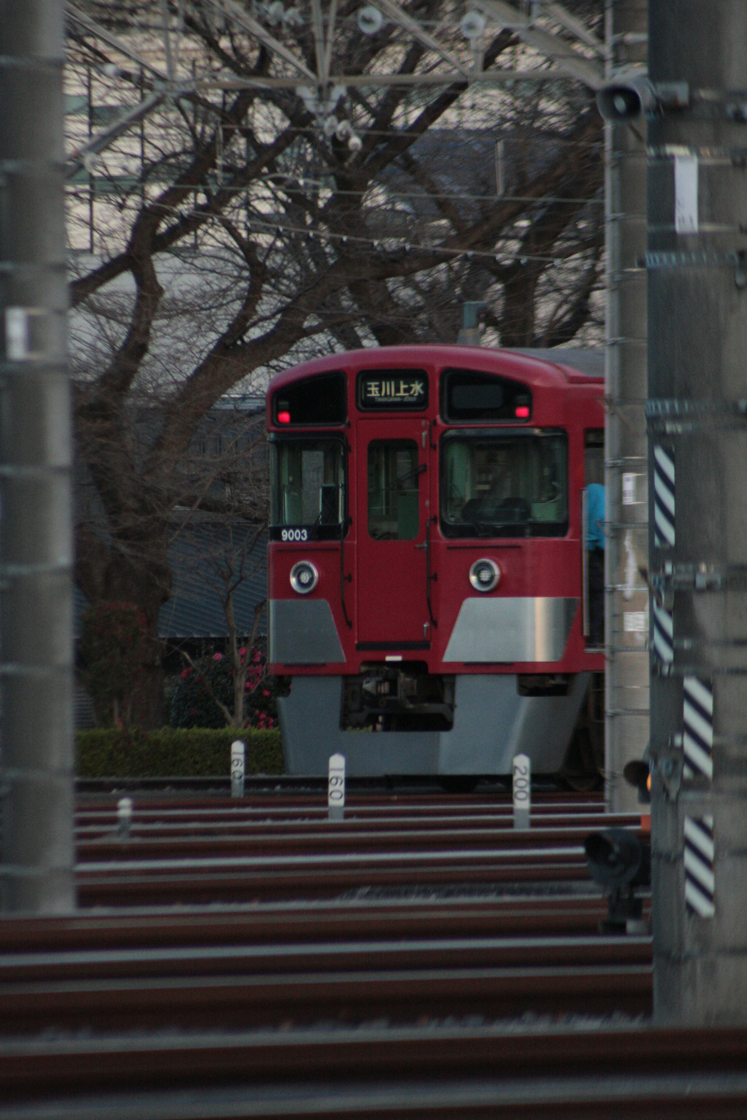 線路を走る赤い路面電車の正面
