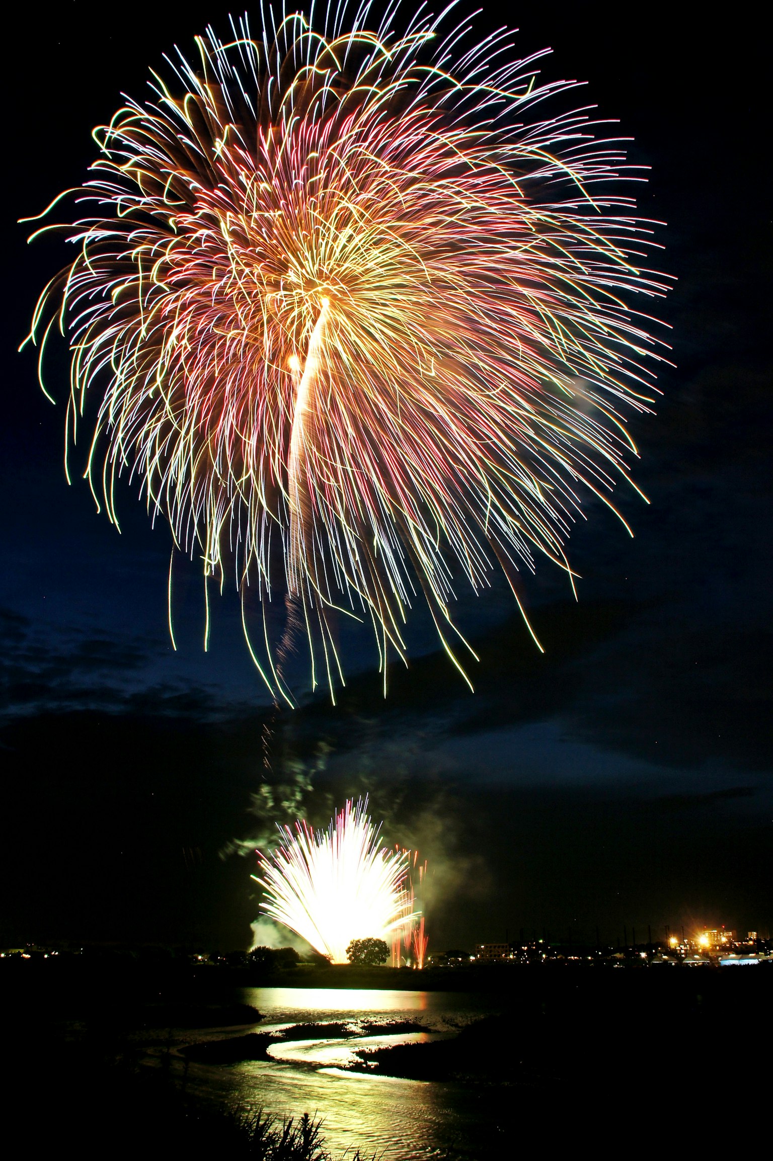 A vibrant fireworks display lighting up the night sky with reflections on the water