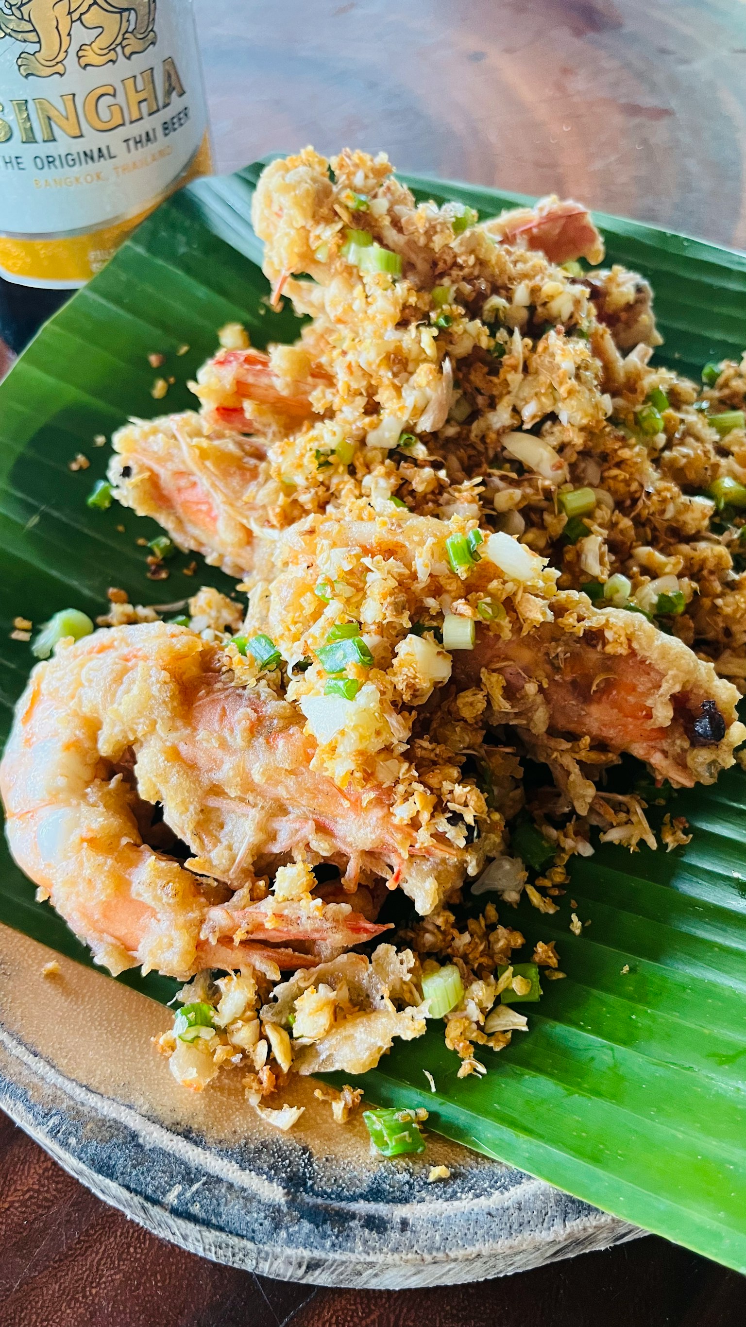美味的虾菜肴放在香蕉叶上，配有酥脆的配料和青葱