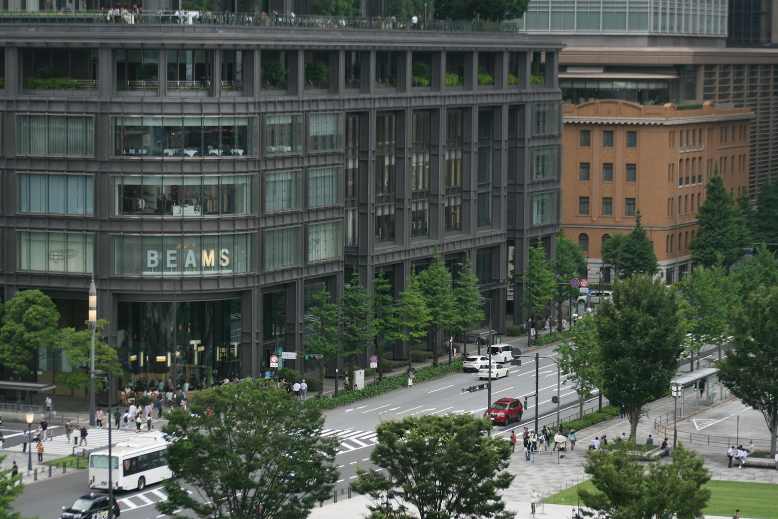 อาคารสมัยใหม่พร้อมทิวทัศน์ถนนสีเขียวที่มีป้าย BEAMS