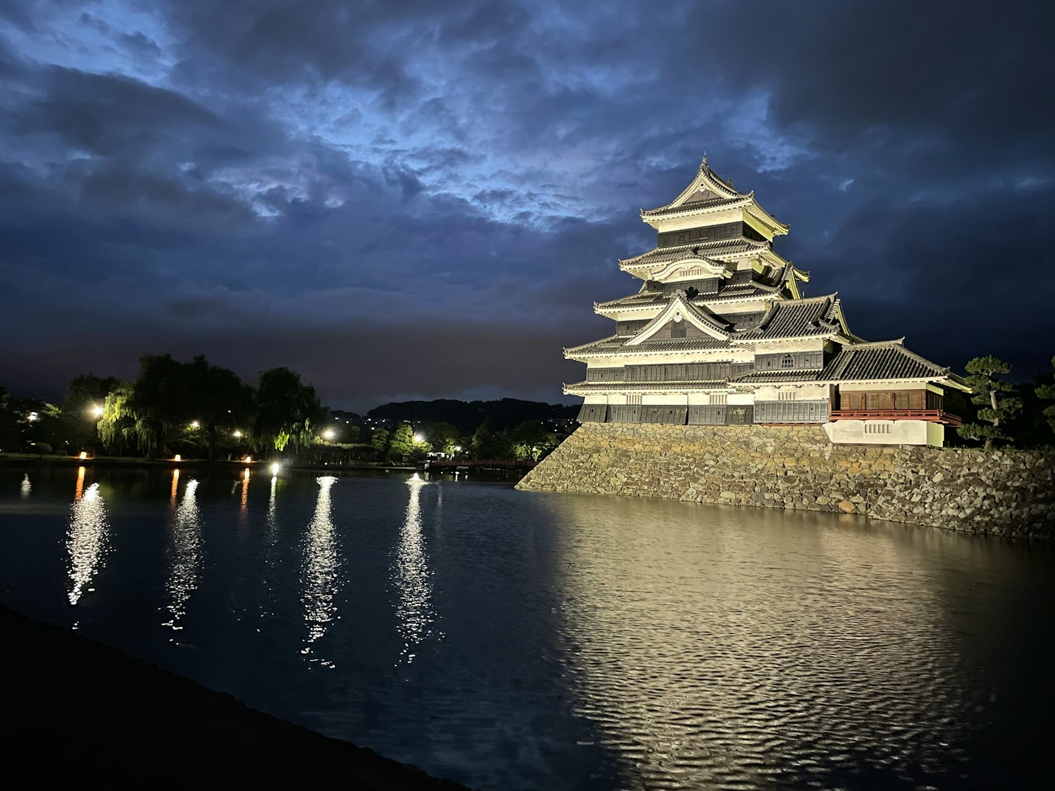 Bella vista del castello di Matsumoto che si riflette nell'acqua di notte