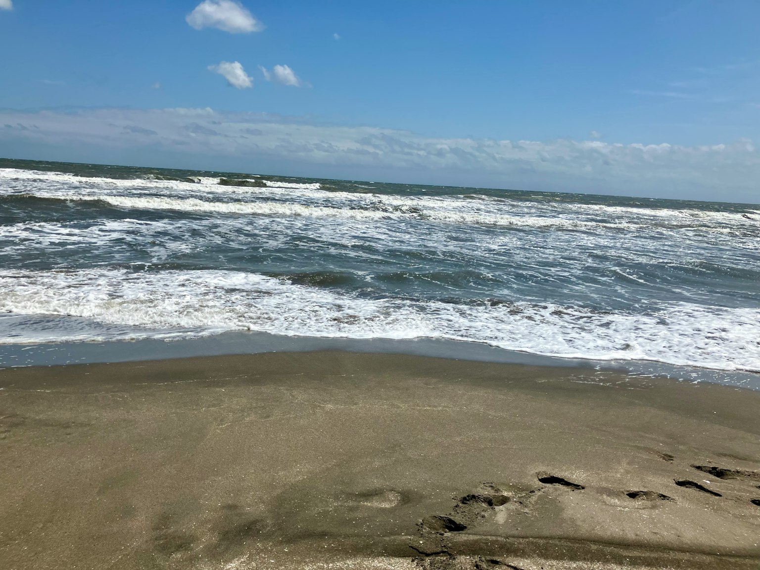 Vista de una playa de arena con olas rompiendo