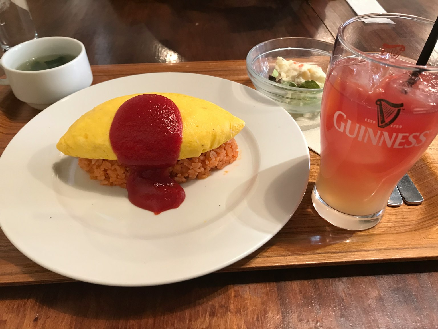 Piring omurice dengan saus tomat dan segelas koktail