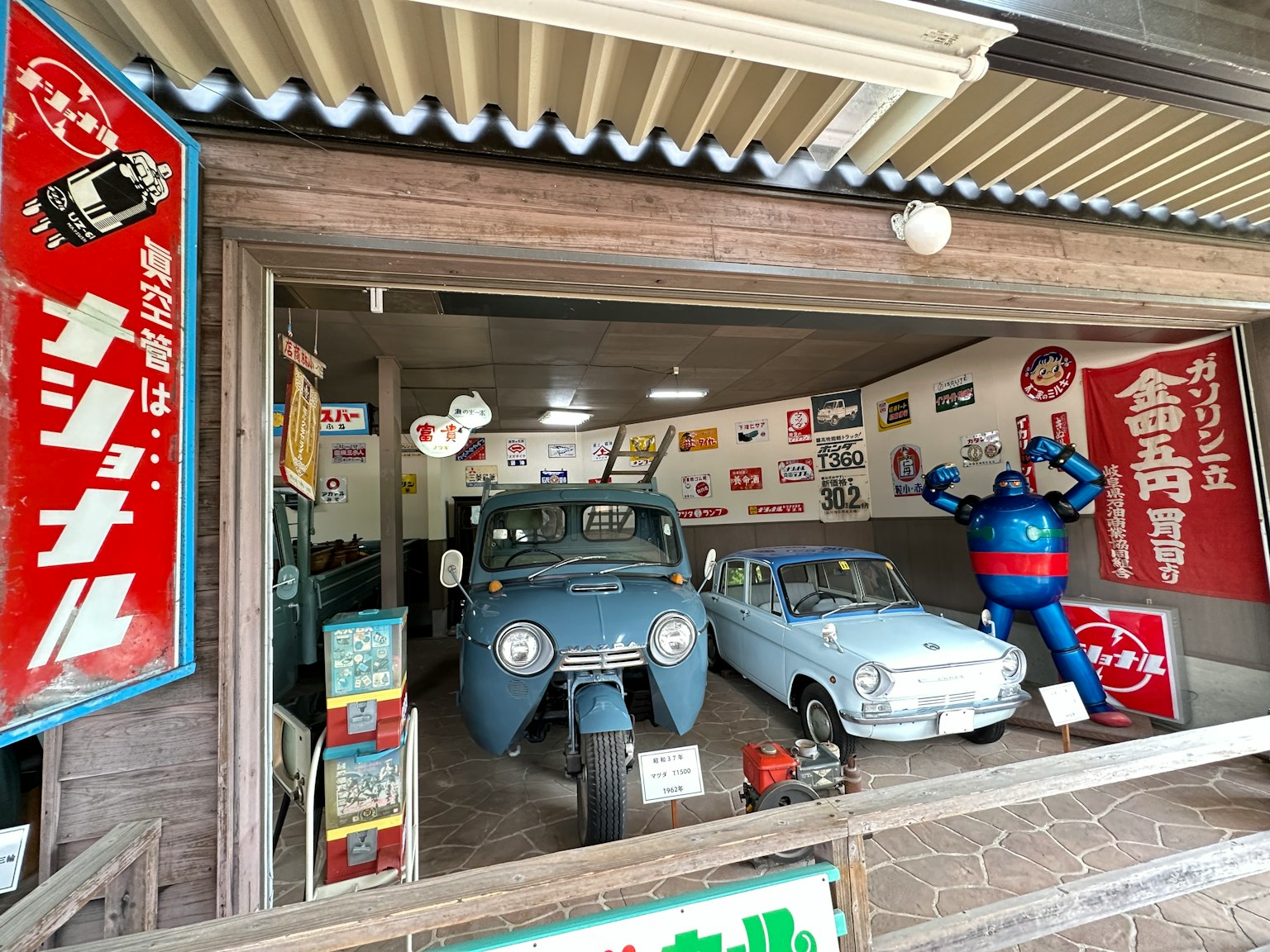 博物館內部展示日本復古汽車藍色和白色汽車旁邊有復古海報和標誌