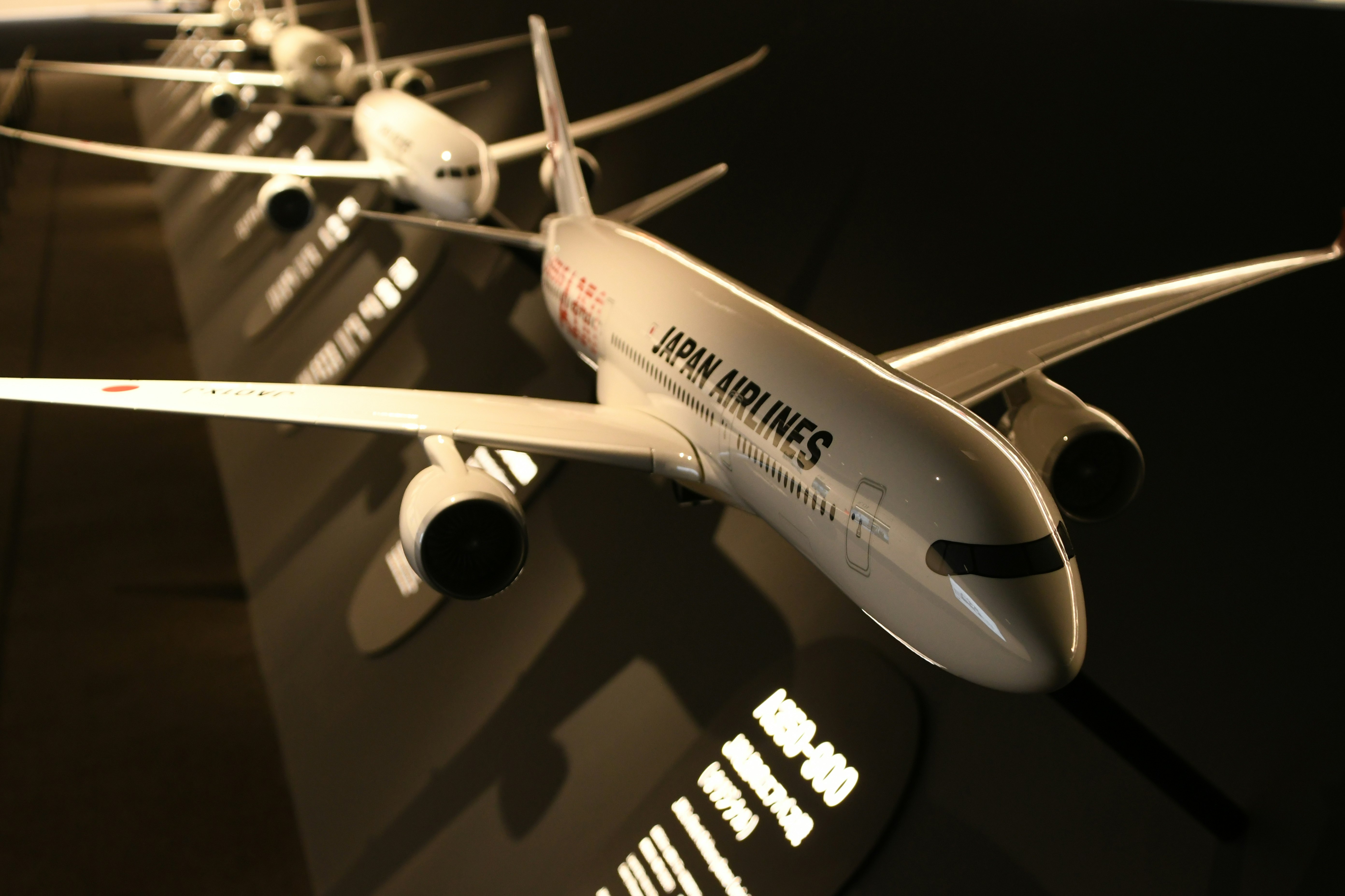 夜の展示スペースで並ぶ飛行機の機体画像