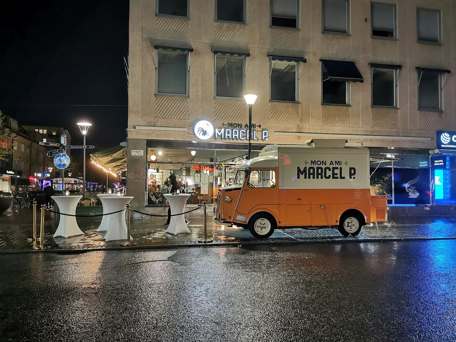 夜间停靠在Marcel标志附近的橙色餐车