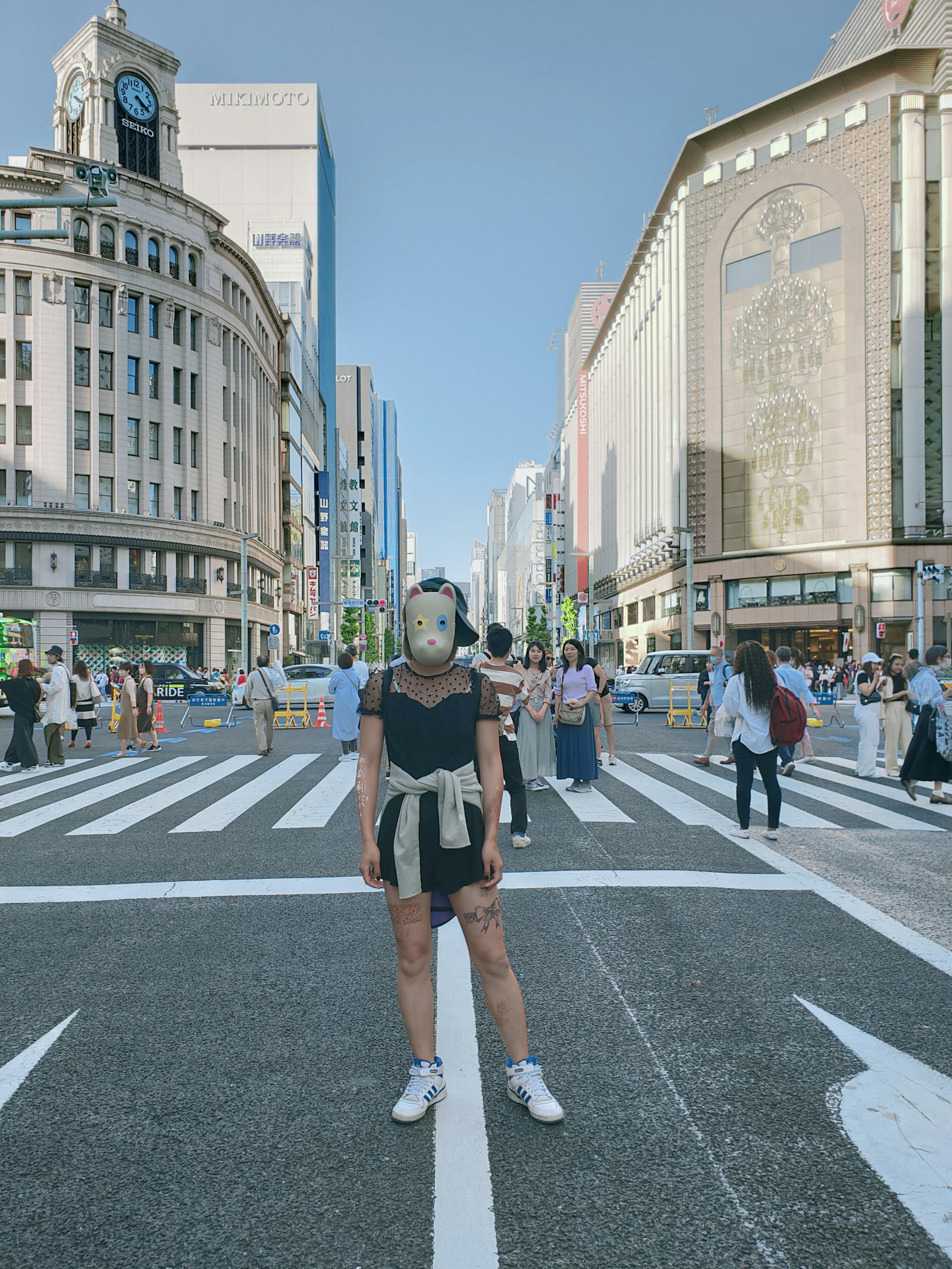 Một người phụ nữ trong trang phục đường phố đứng tại vạch qua đường ở Ginza