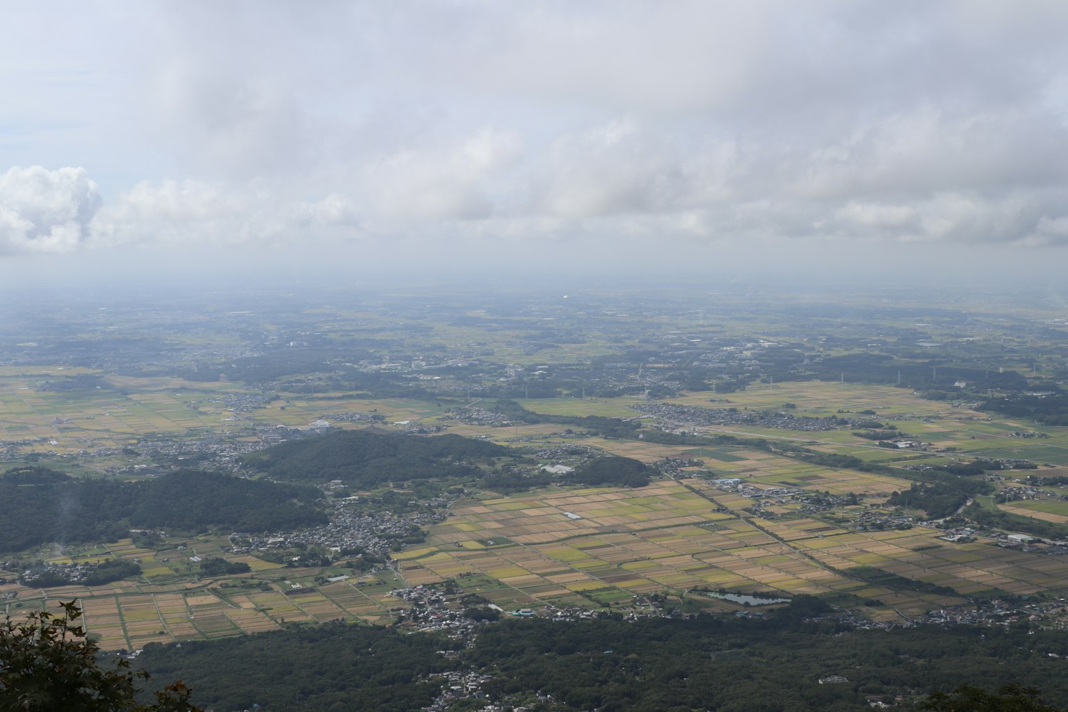 Vista panoramica di un ampio paesaggio con cielo nuvoloso e campi verdi