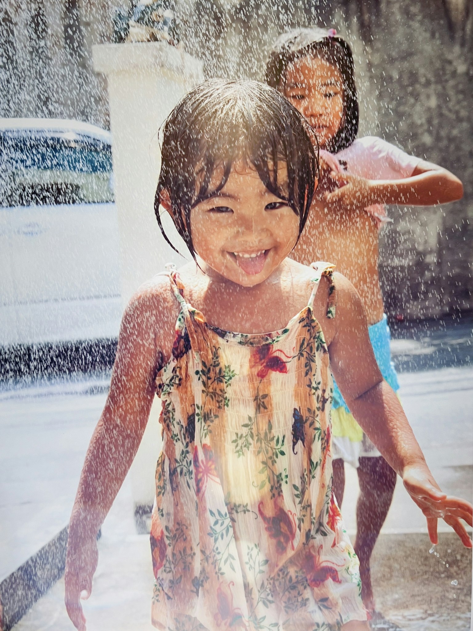 Children playing joyfully in water spray with smiles