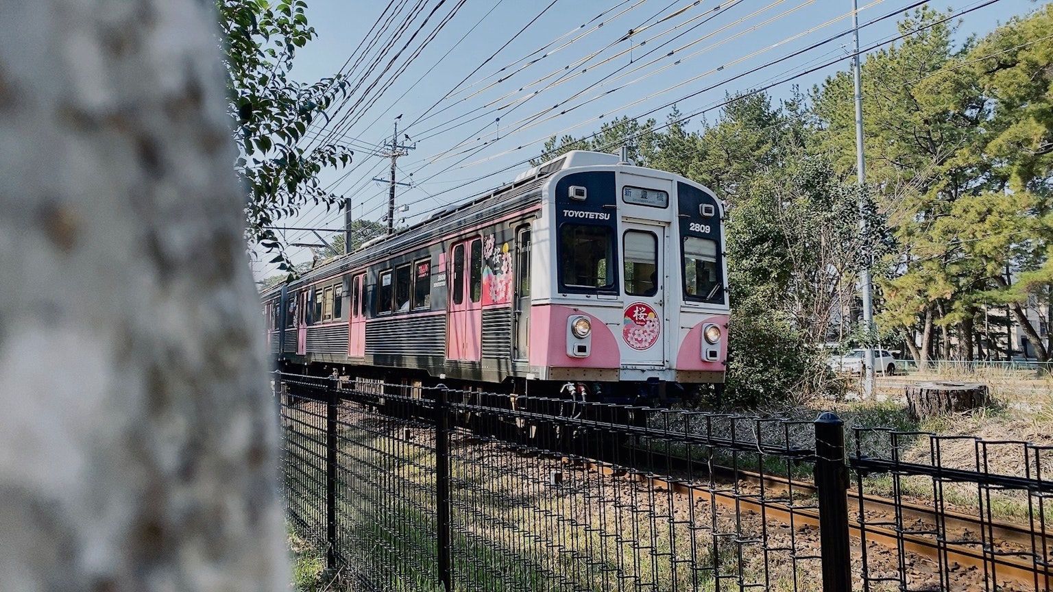 A pink train running along the tracks