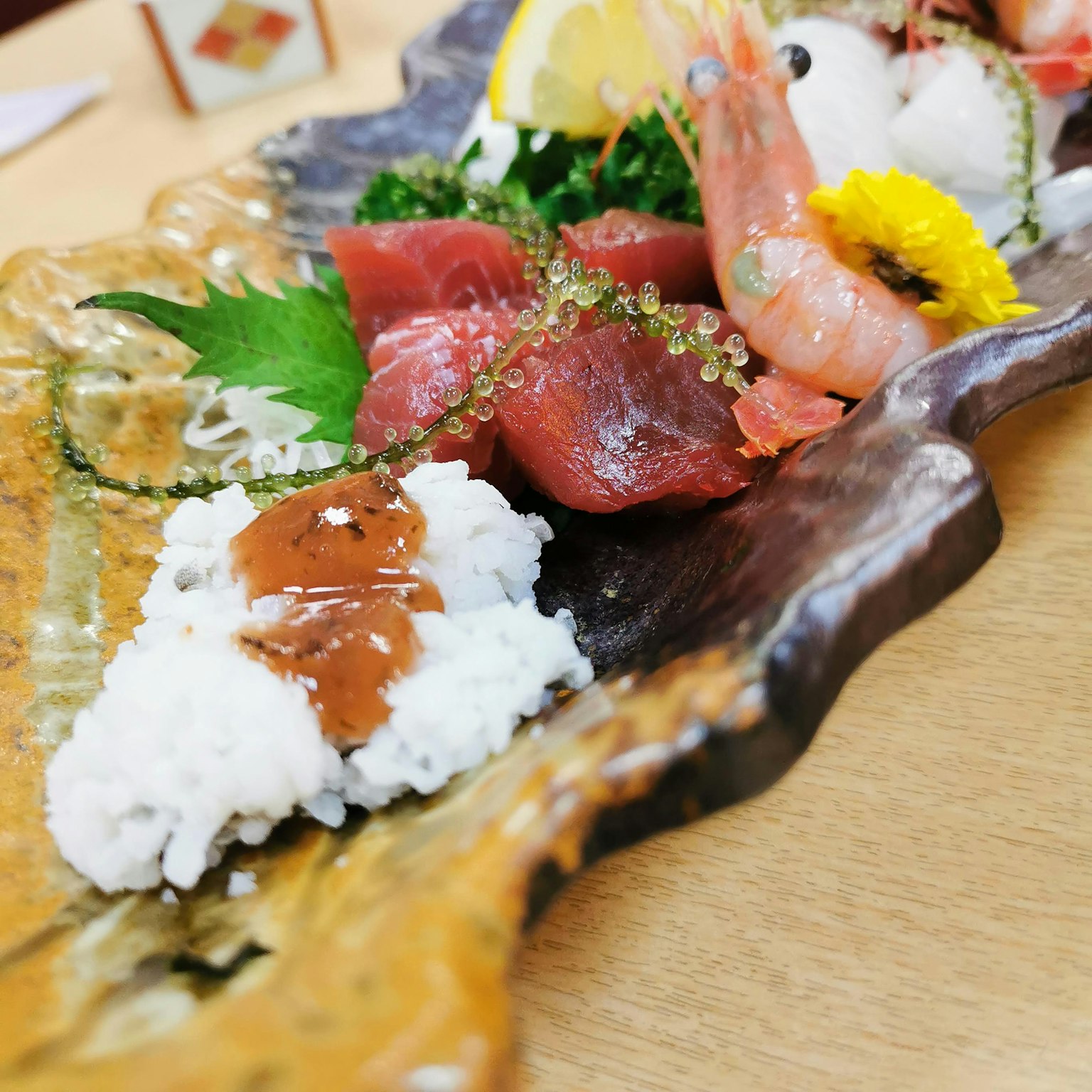 Piring yang indah disajikan dengan sashimi segar dan udang