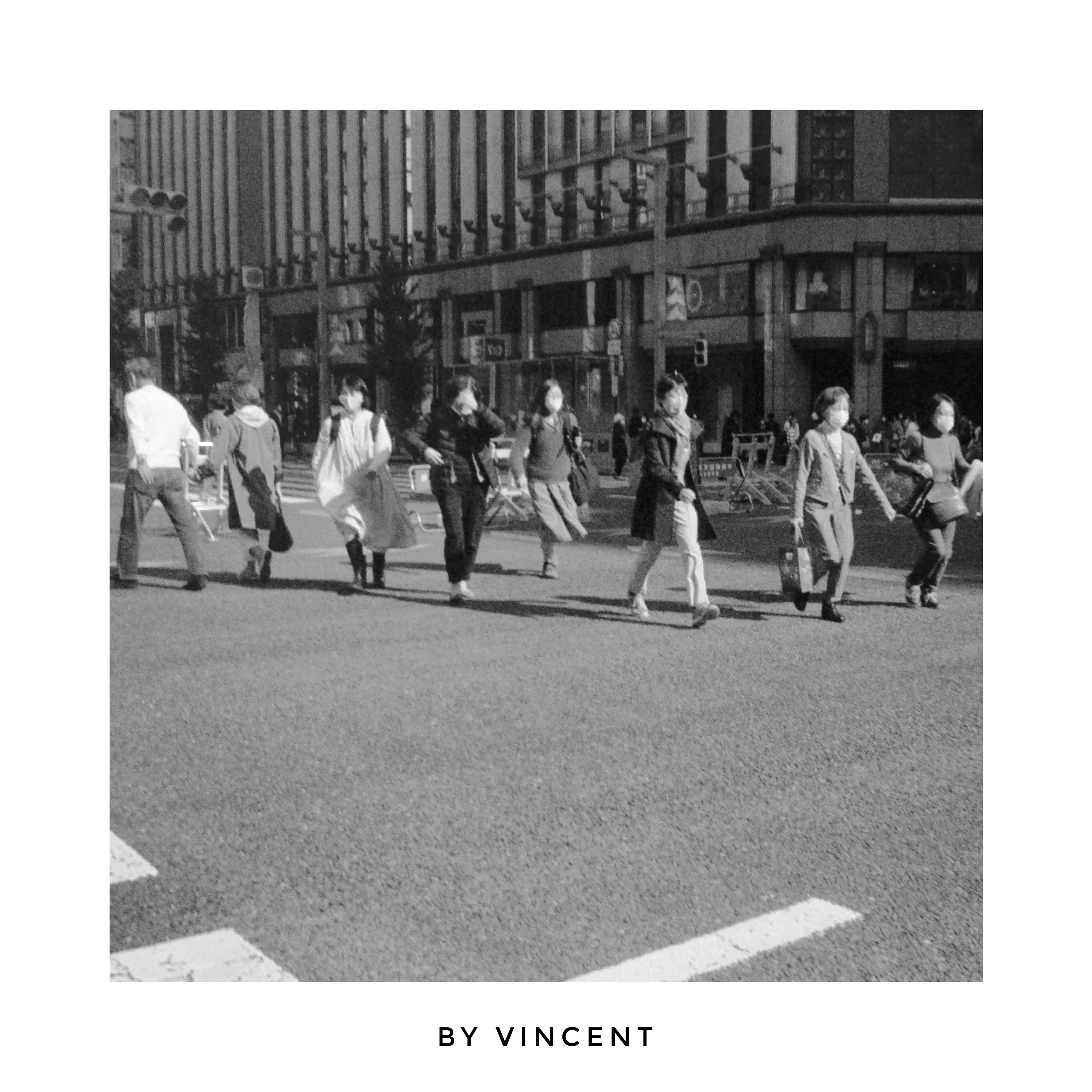 urban street corner with people walking across a crosswalk
