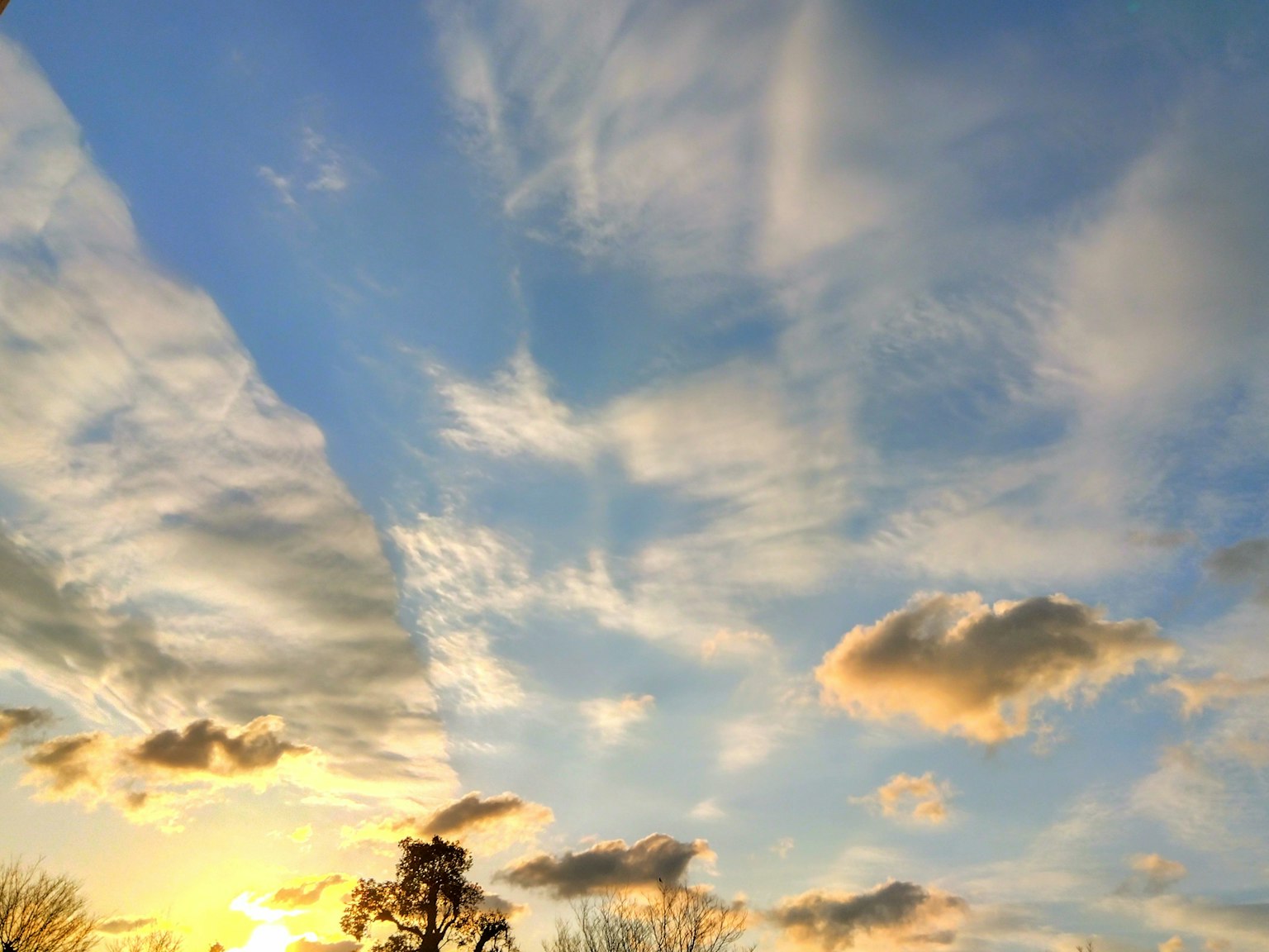 A serene sky with white clouds and a sunset