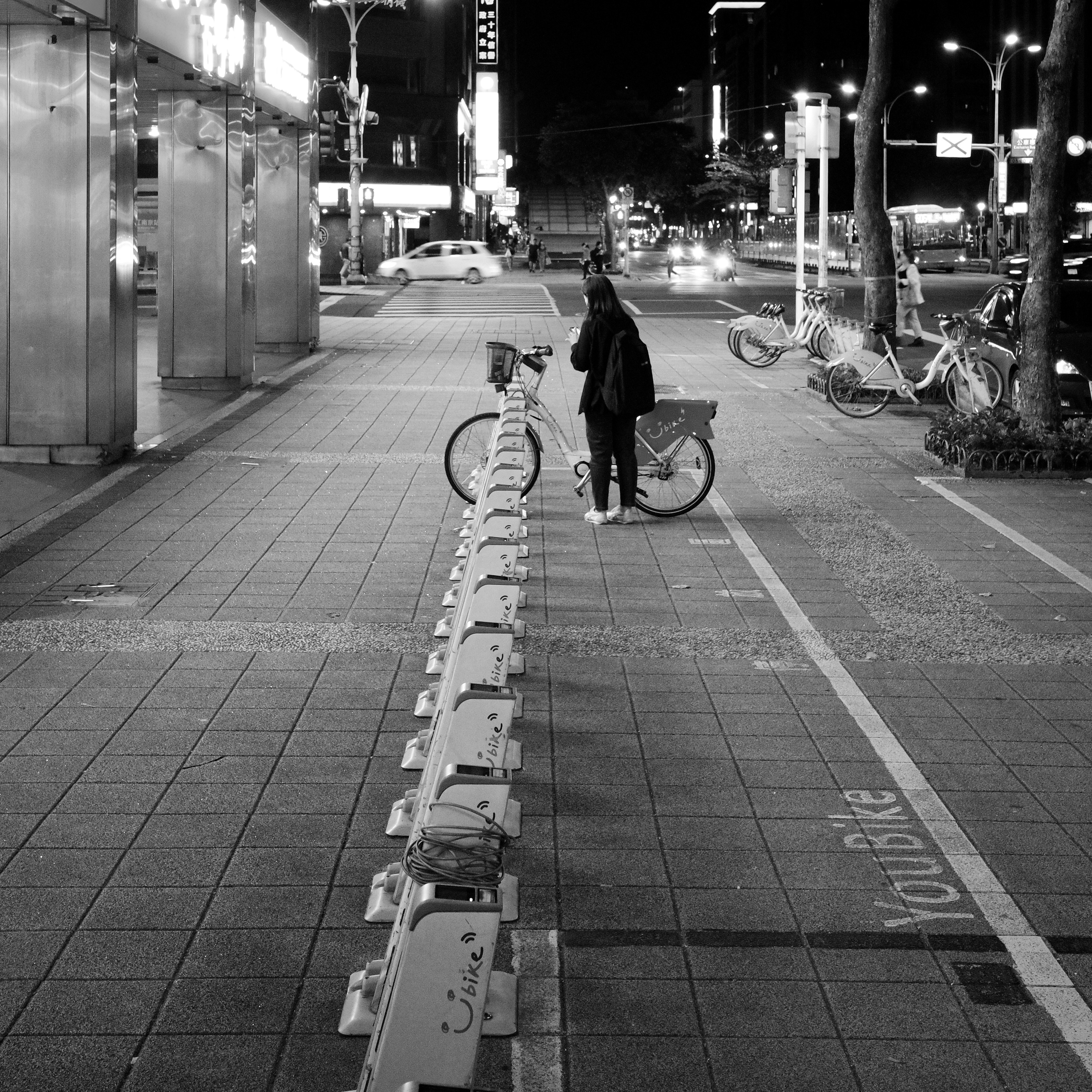 Taipei sidewalk with shared bicycles at night