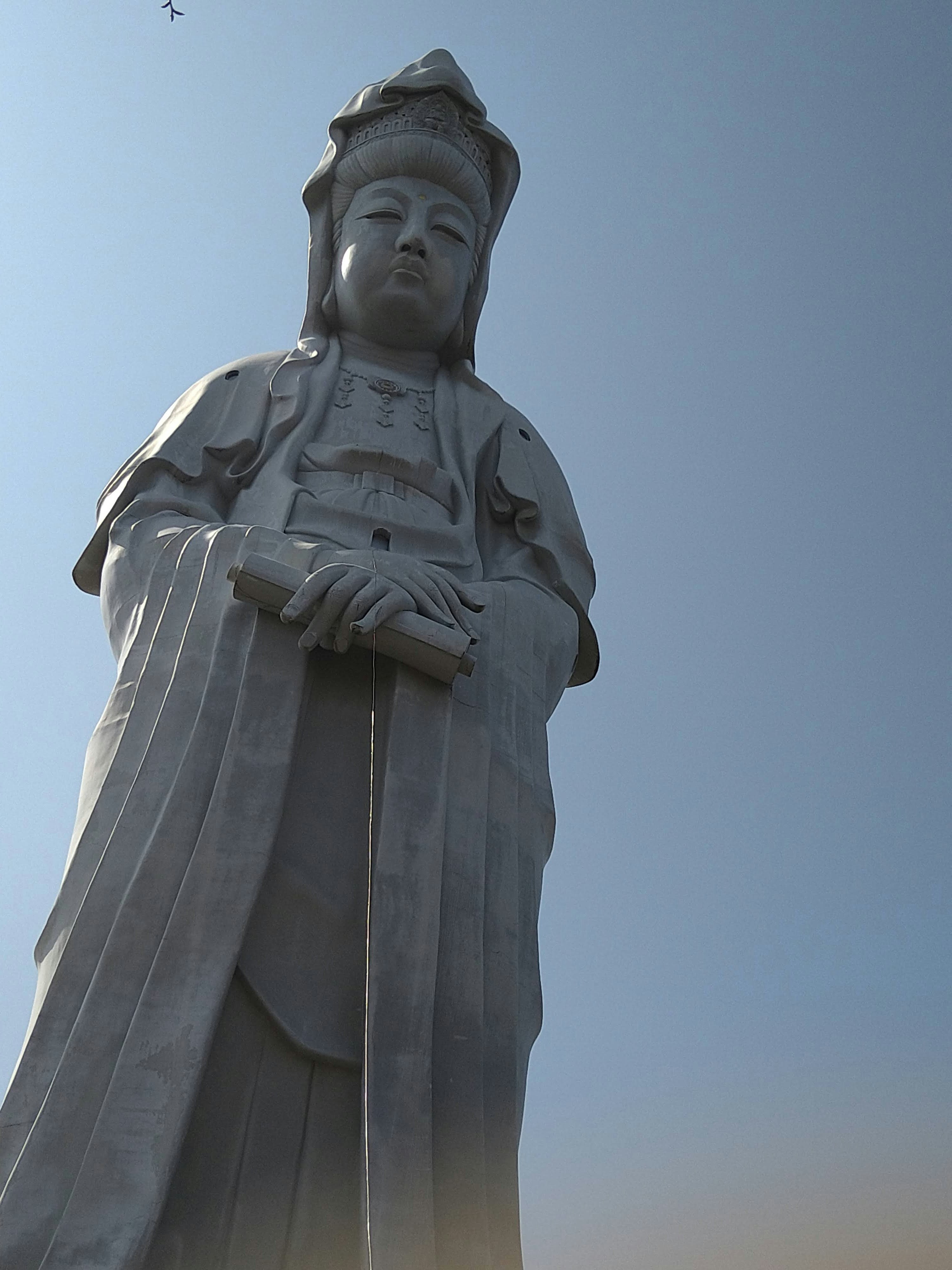 푸른 하늘 아래 서 있는 석상 무사상