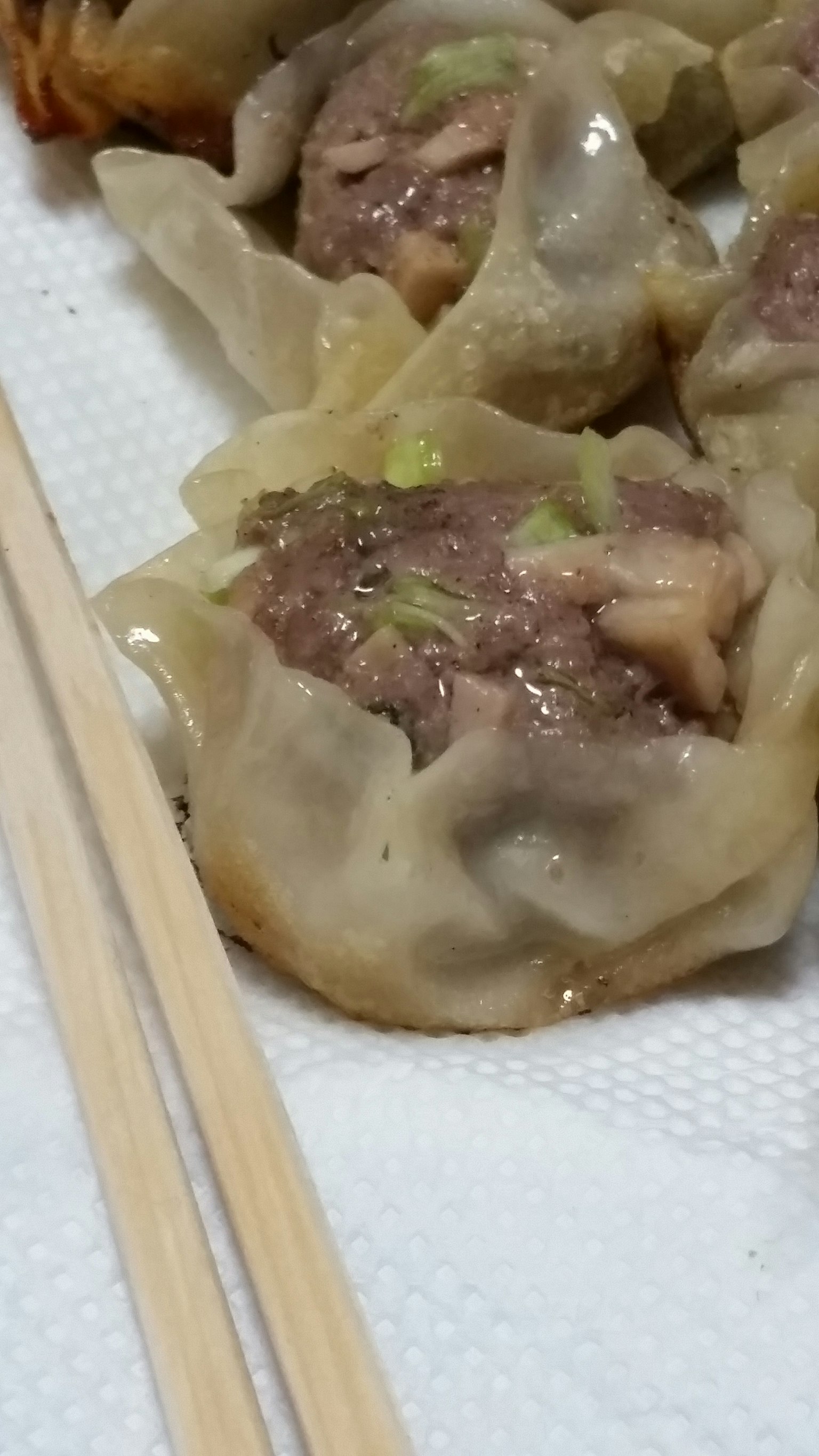 Cận cảnh há cảo nhân thịt trên đĩa với đũa