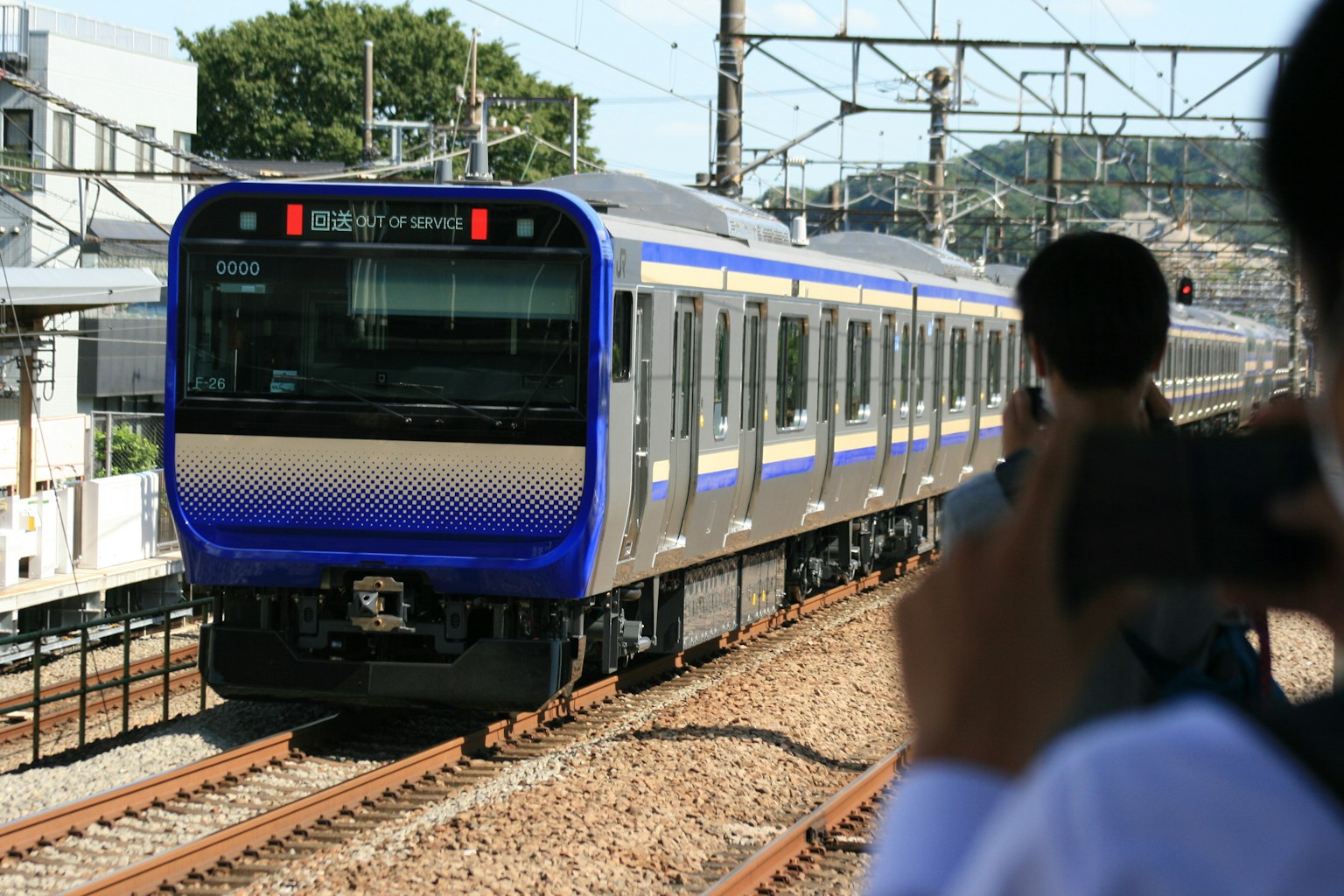 Treno blu che corre sui binari in una stazione
