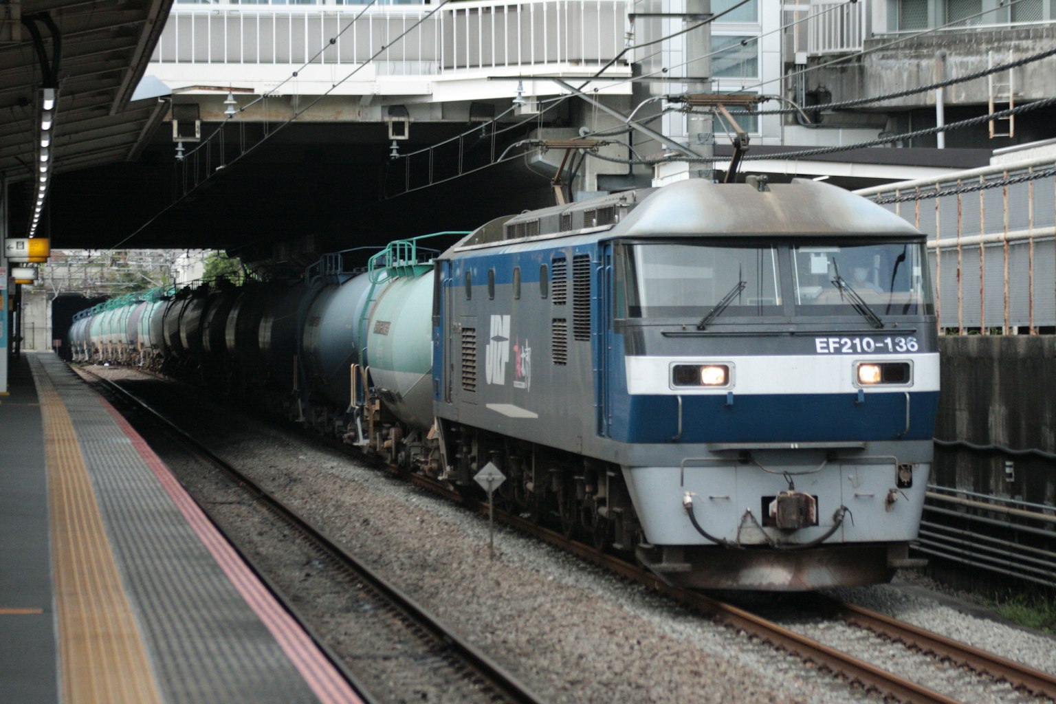 Tren de carga azul llegando a una estación