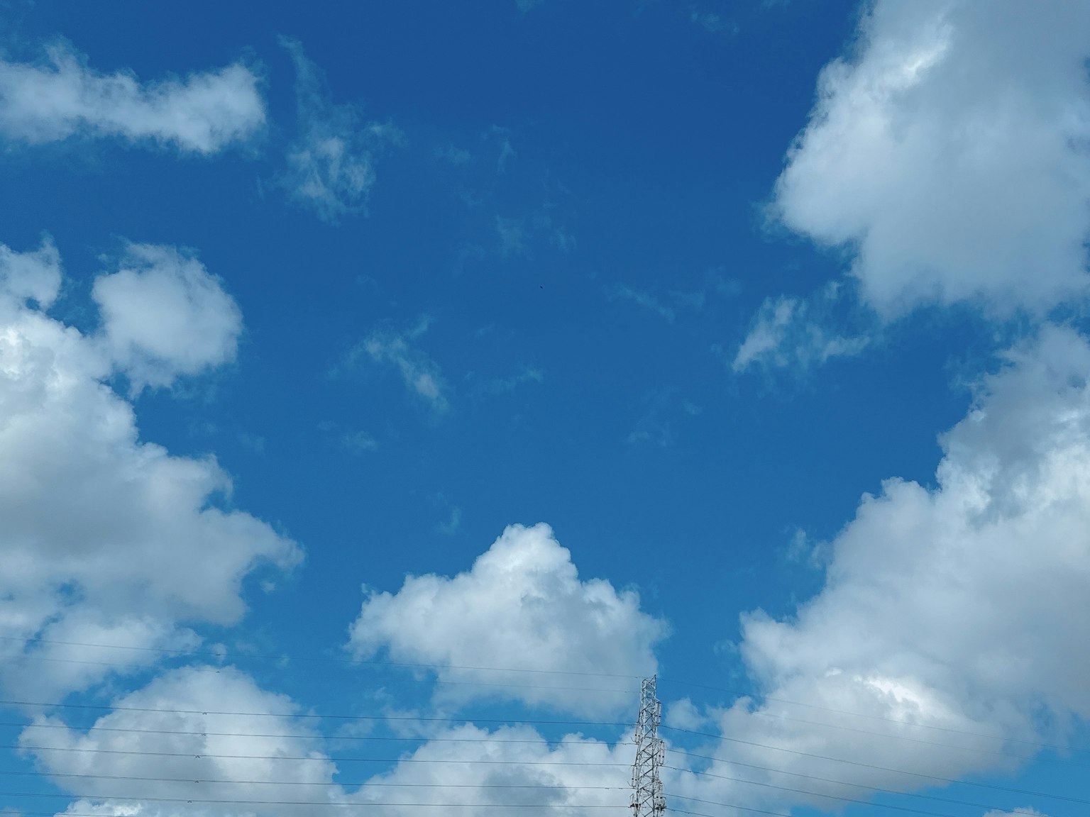 Ein klarer blauer Himmel mit flauschigen weißen Wolken