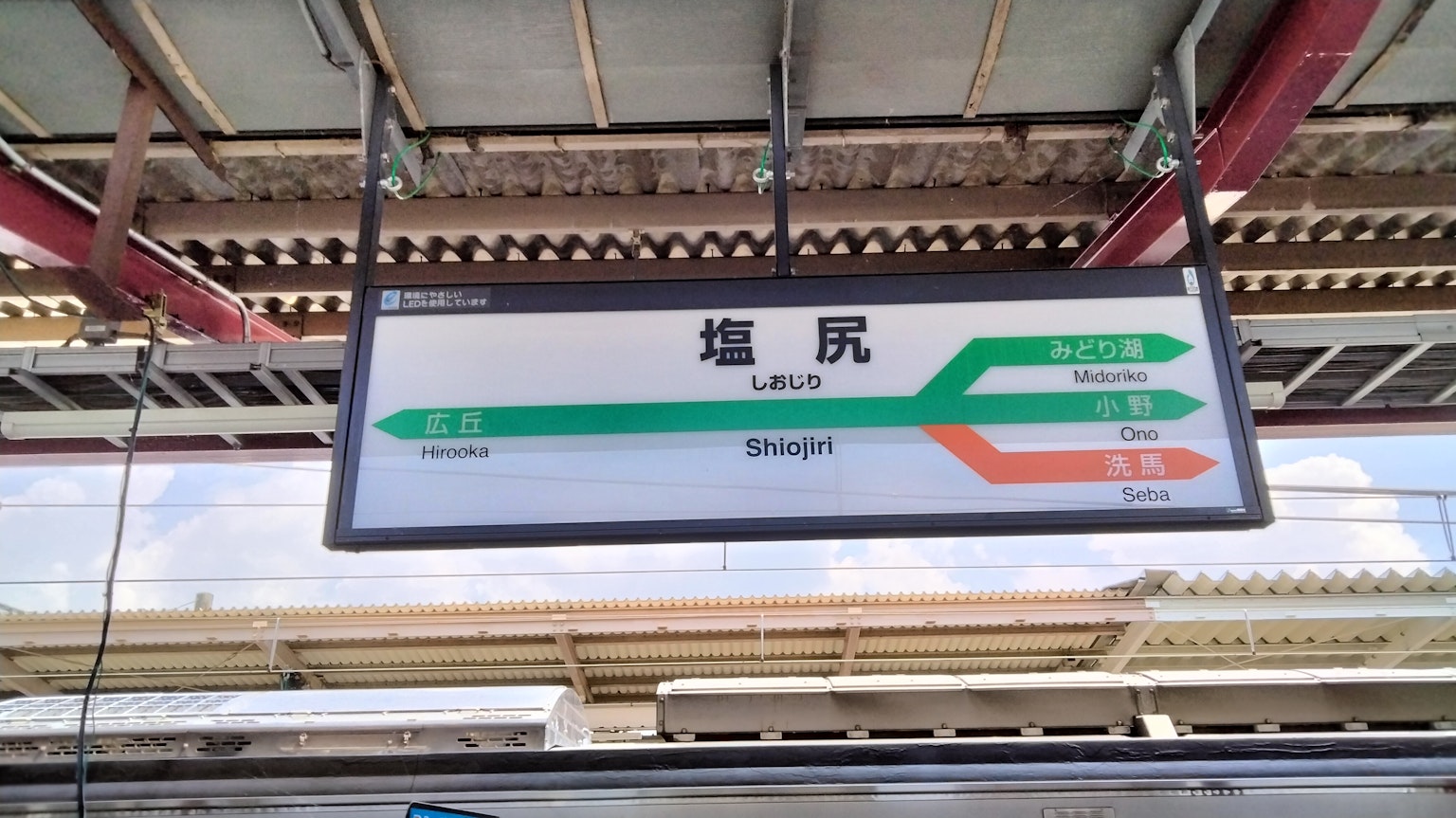 Green train station sign displaying station name