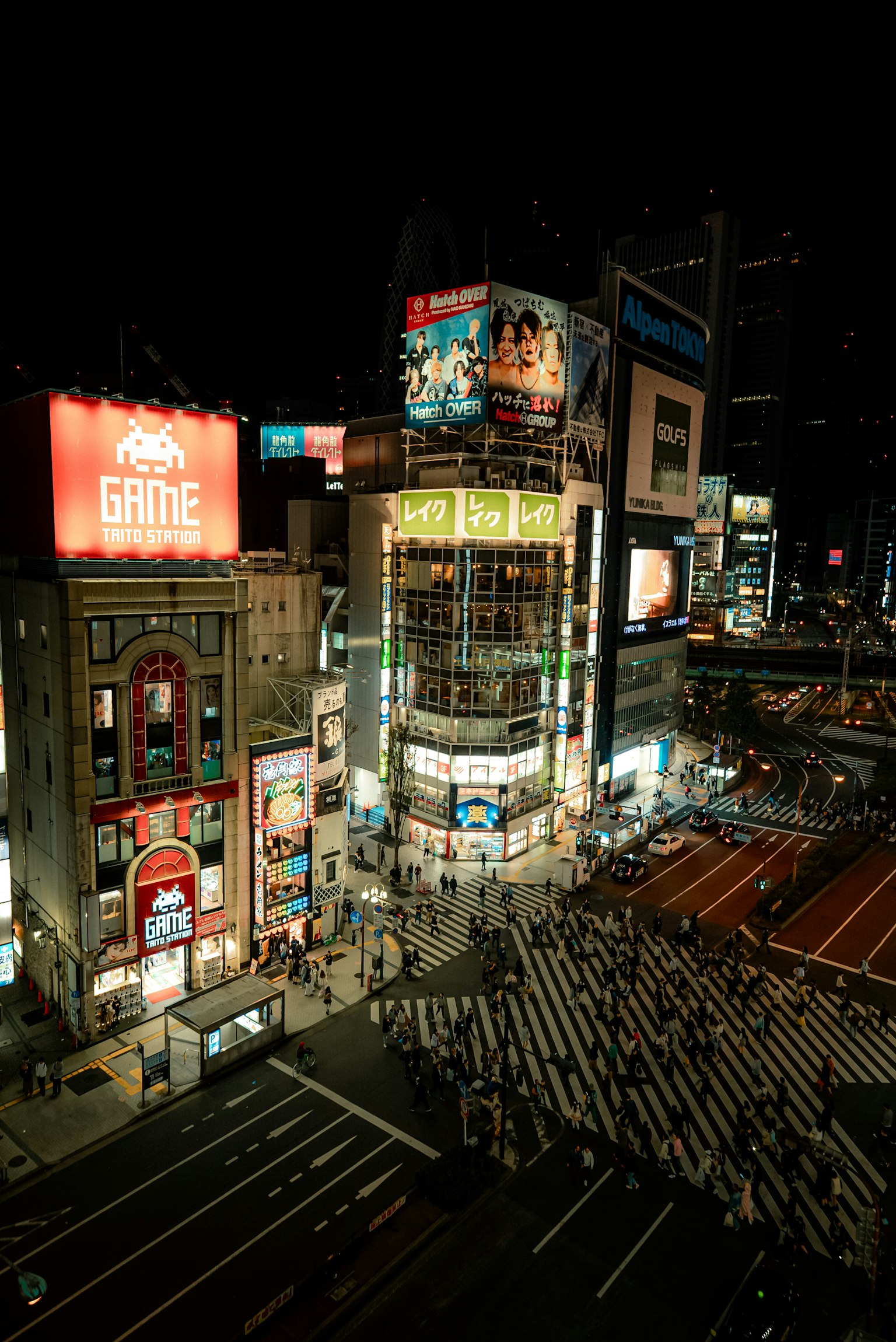 Incrocio affollato di Shibuya di notte con insegne al neon