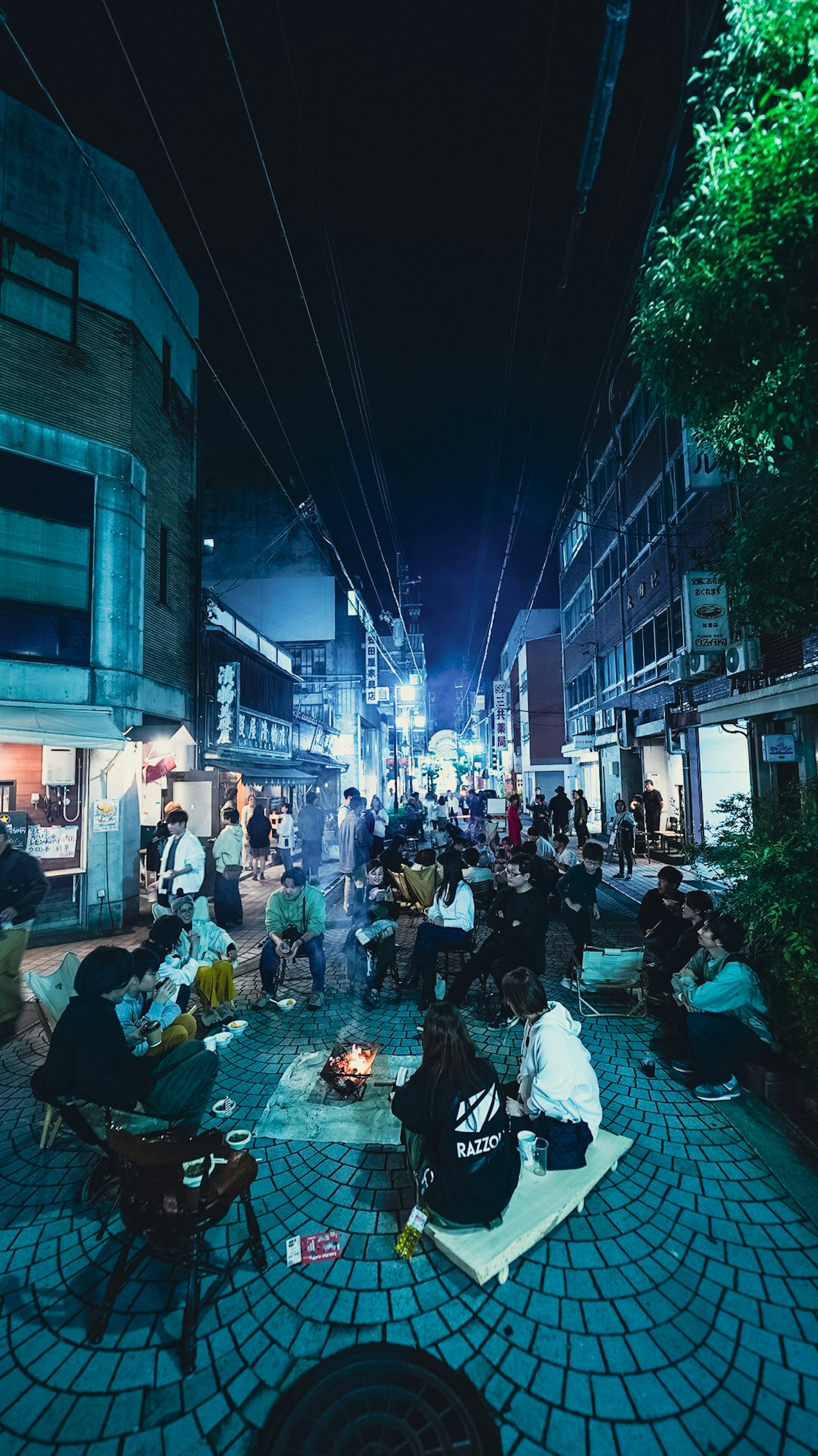 夜晚街道上人們圍坐在小火堆旁的場景