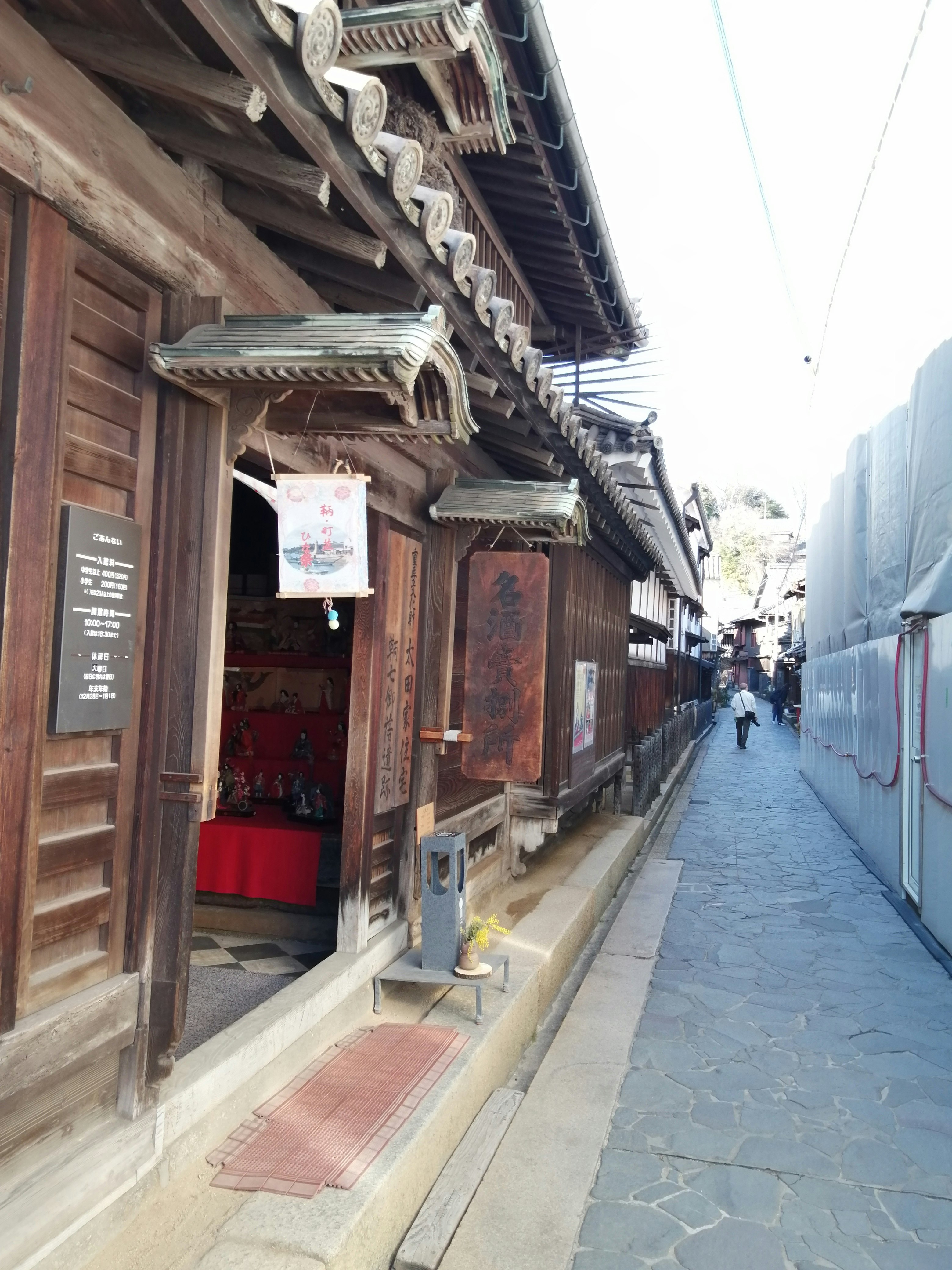 ร้านไม้เรียงรายและป้ายแขวนตามตรอกแคบ