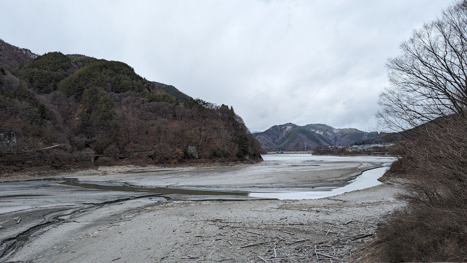 宁静的河流景观，雾气缭绕的山脉和干燥的河床