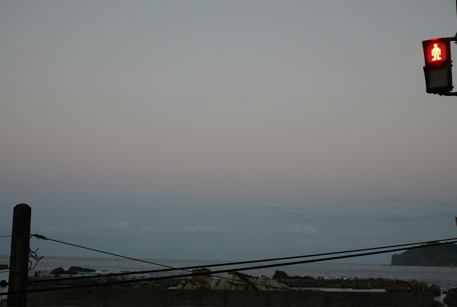 夕暮れ時の海の景色と赤い信号灯